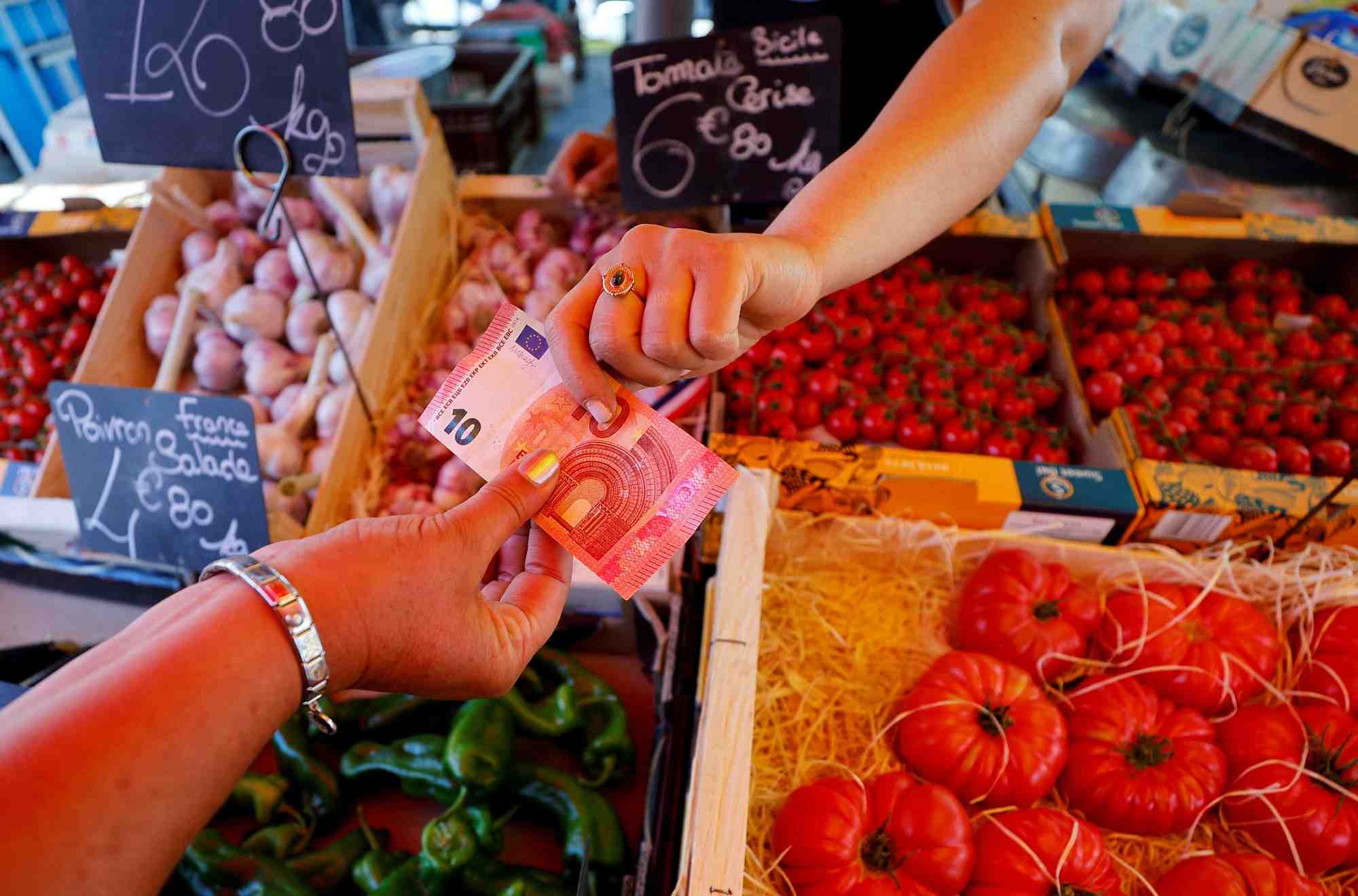 Photo d'archives d'un acheteur qui paie avec un billet de dix euros au marche local a nice
