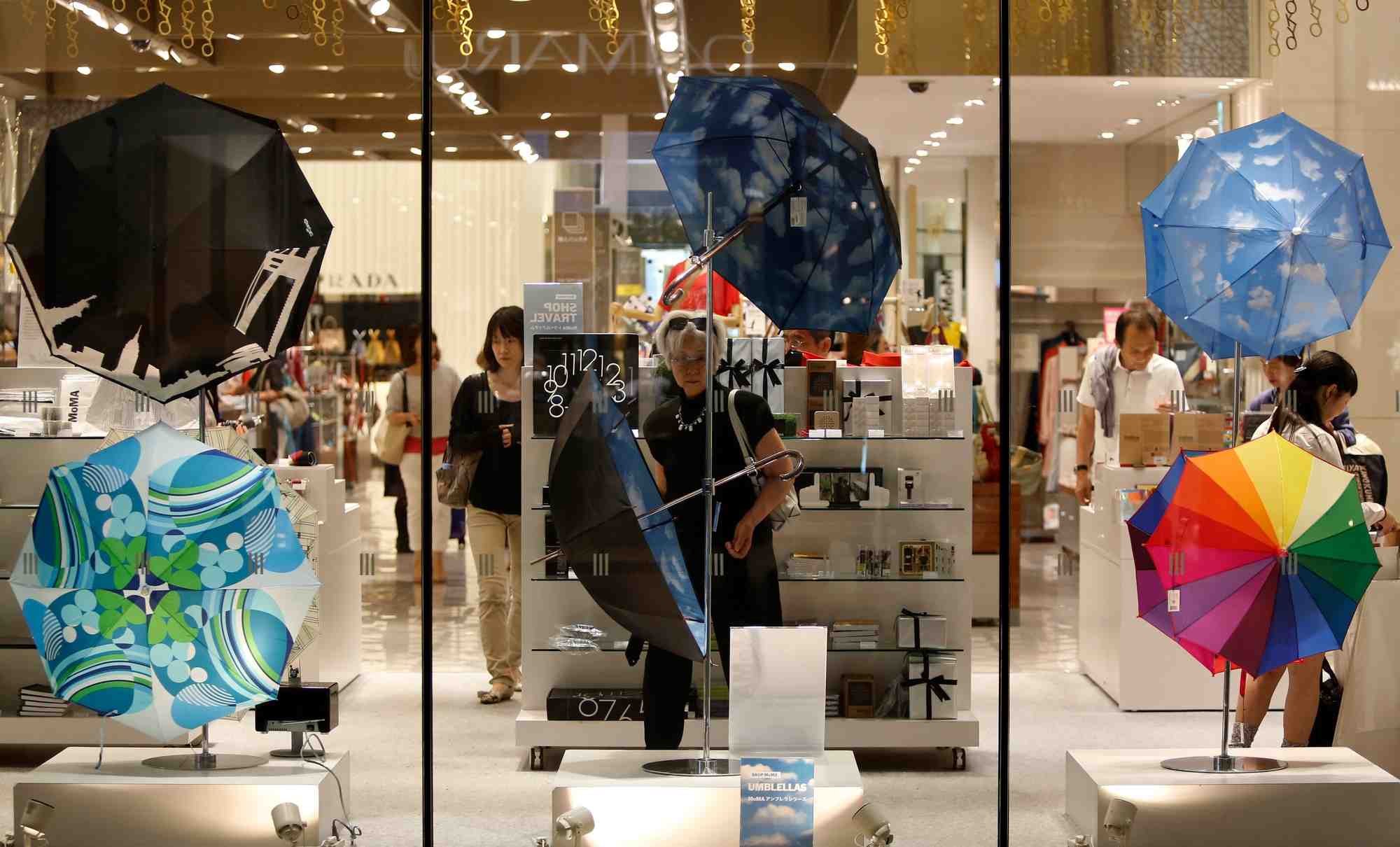 Une femme regarde des parapluies exposes dans un grand magasin de luxe a tokyo