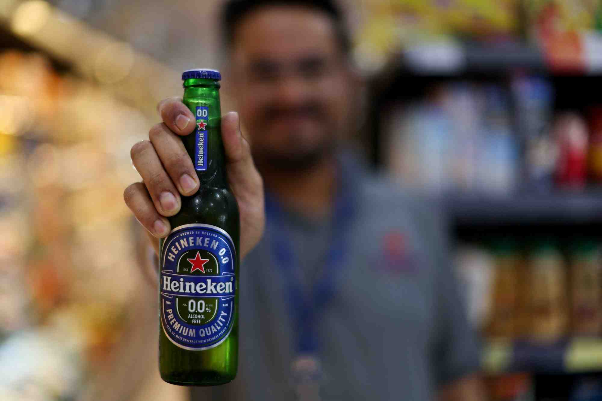 Un vendeur montre une boisson heineken dans un supermarche au bahrein
