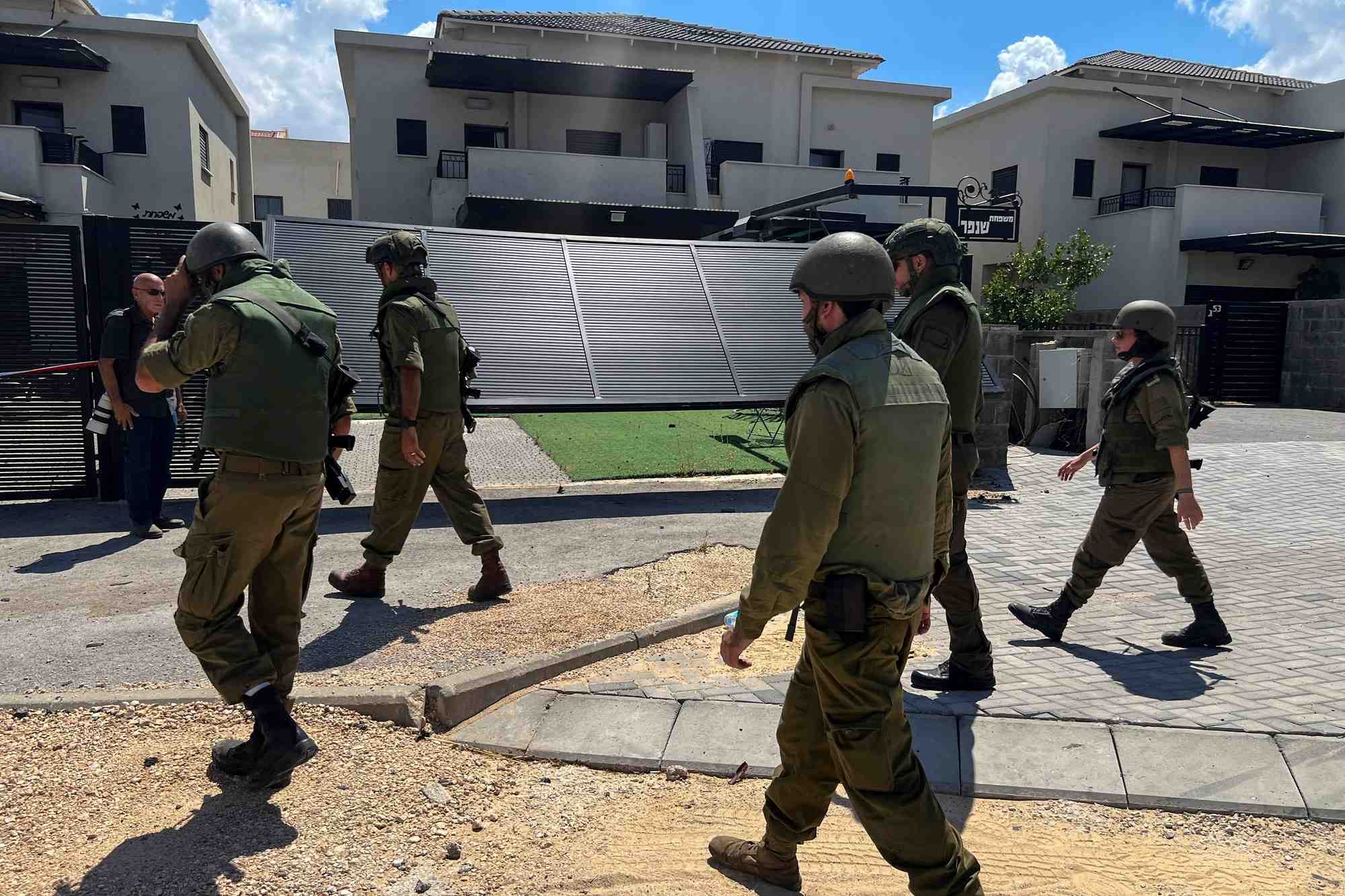 Des soldats israeliens marchent a cote d'un immeuble residentiel endommage dans le nord d'israel.