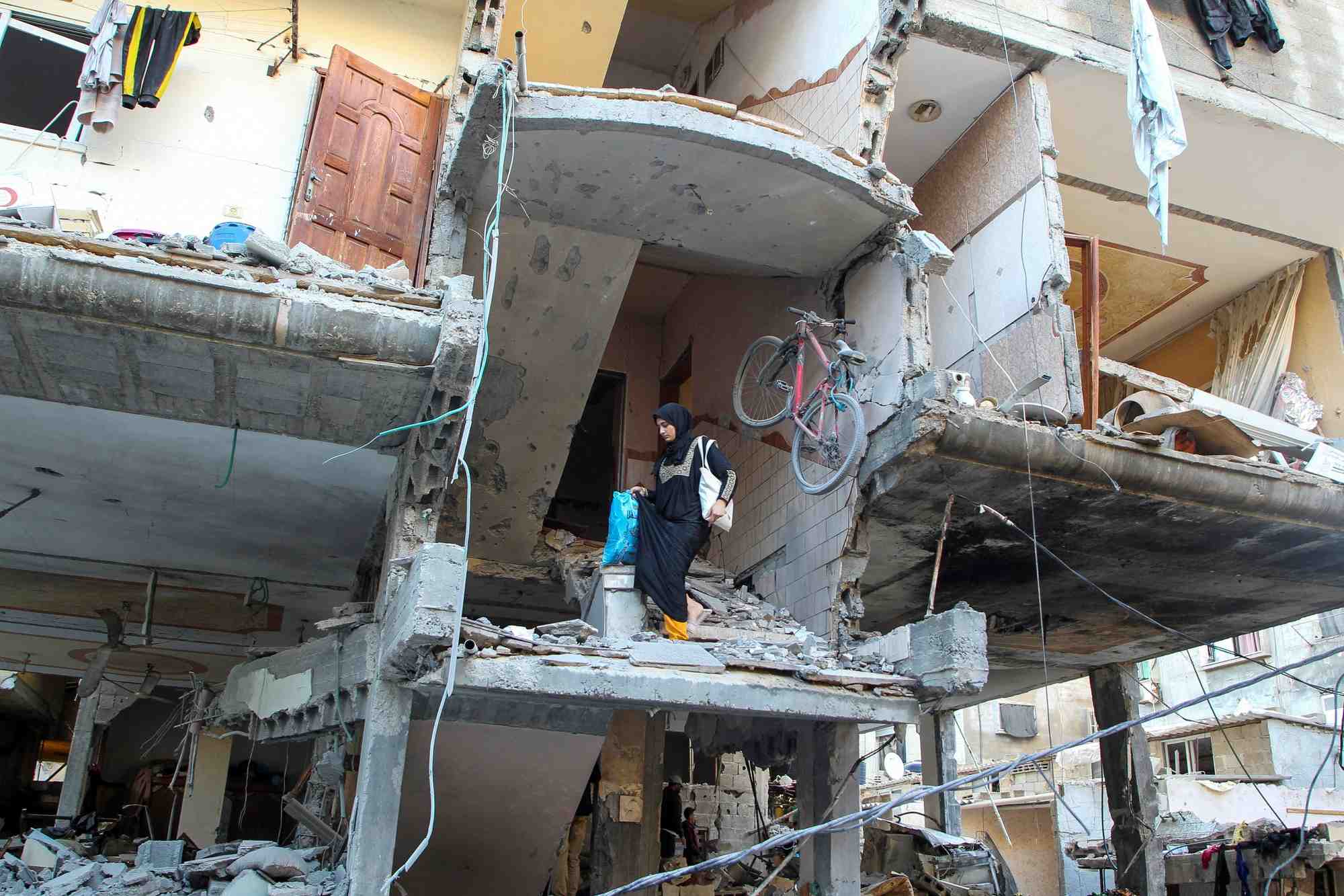 Une femme palestinienne descend les escaliers d'une maison touchee par une frappe israelienne a rafah, dans le sud de la bande de gaza
