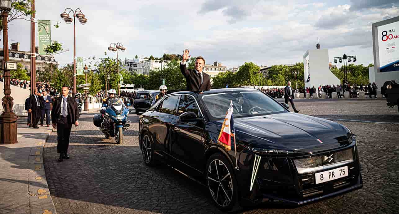 Emmanuel Macron salue la foule depuis le toit ouvrant de sa nouvelle DS8 électrique à l'issue de la cérémonie du 80e anniversaire de la fin de la seconde guerre mondiale, à Paris, le 8 mai 2025.