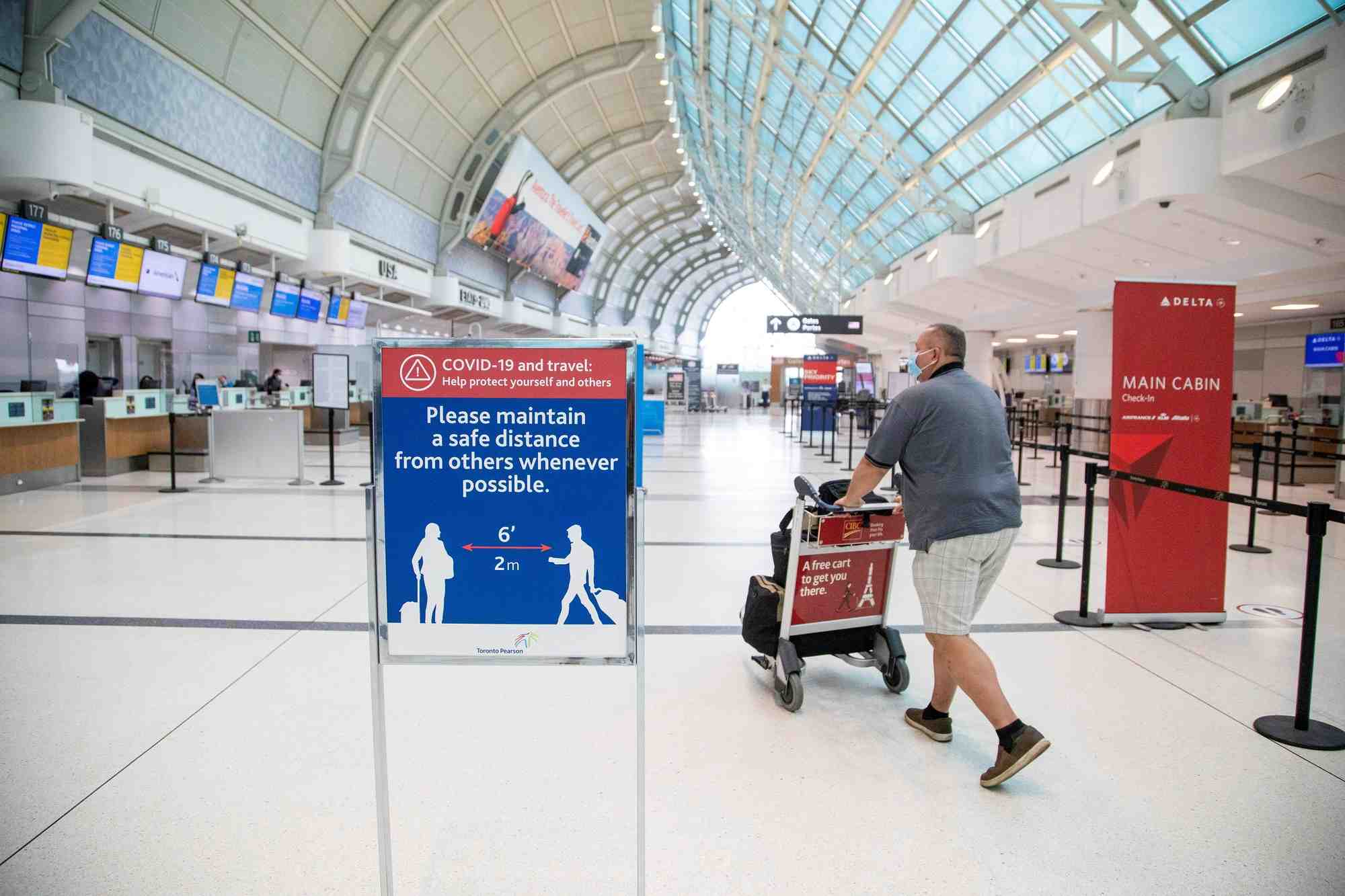 Un homme pousse un chariot a bagages a l'aeroport pearson de toronto