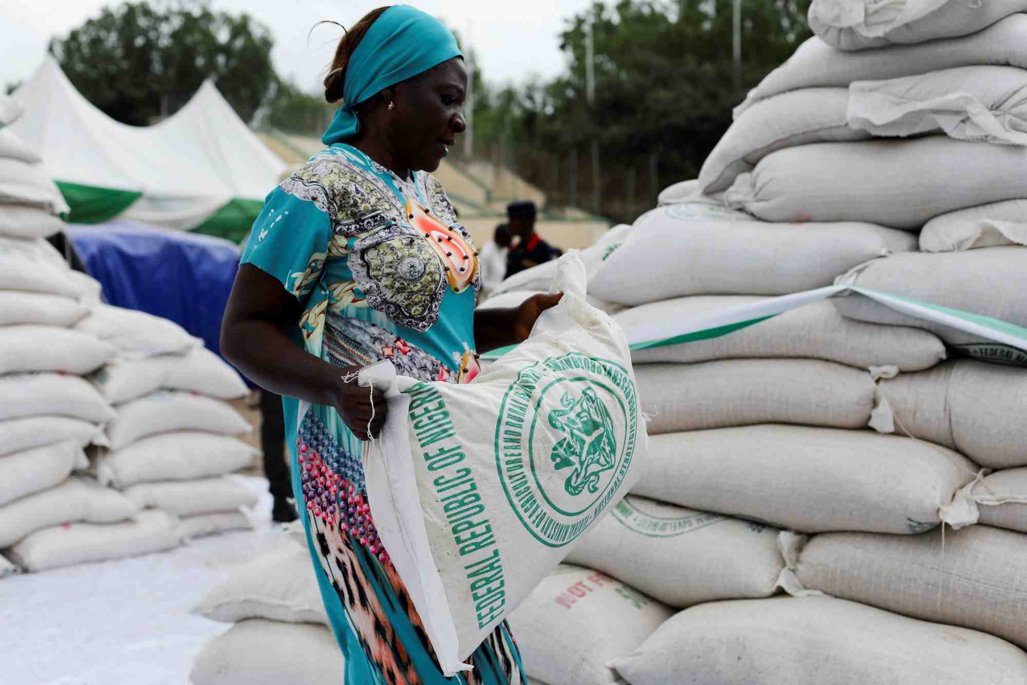 Photo d'une femme qui recoit un sac de nourriture du gouvernement lors de la distribution de produits alimentaires
