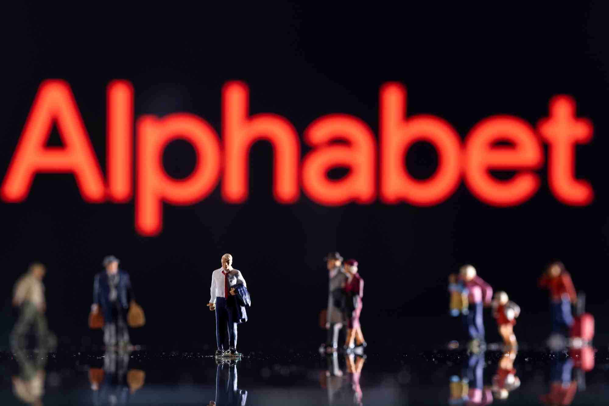 Photo d'illustration de figurines exposees devant le logo d'alphabet