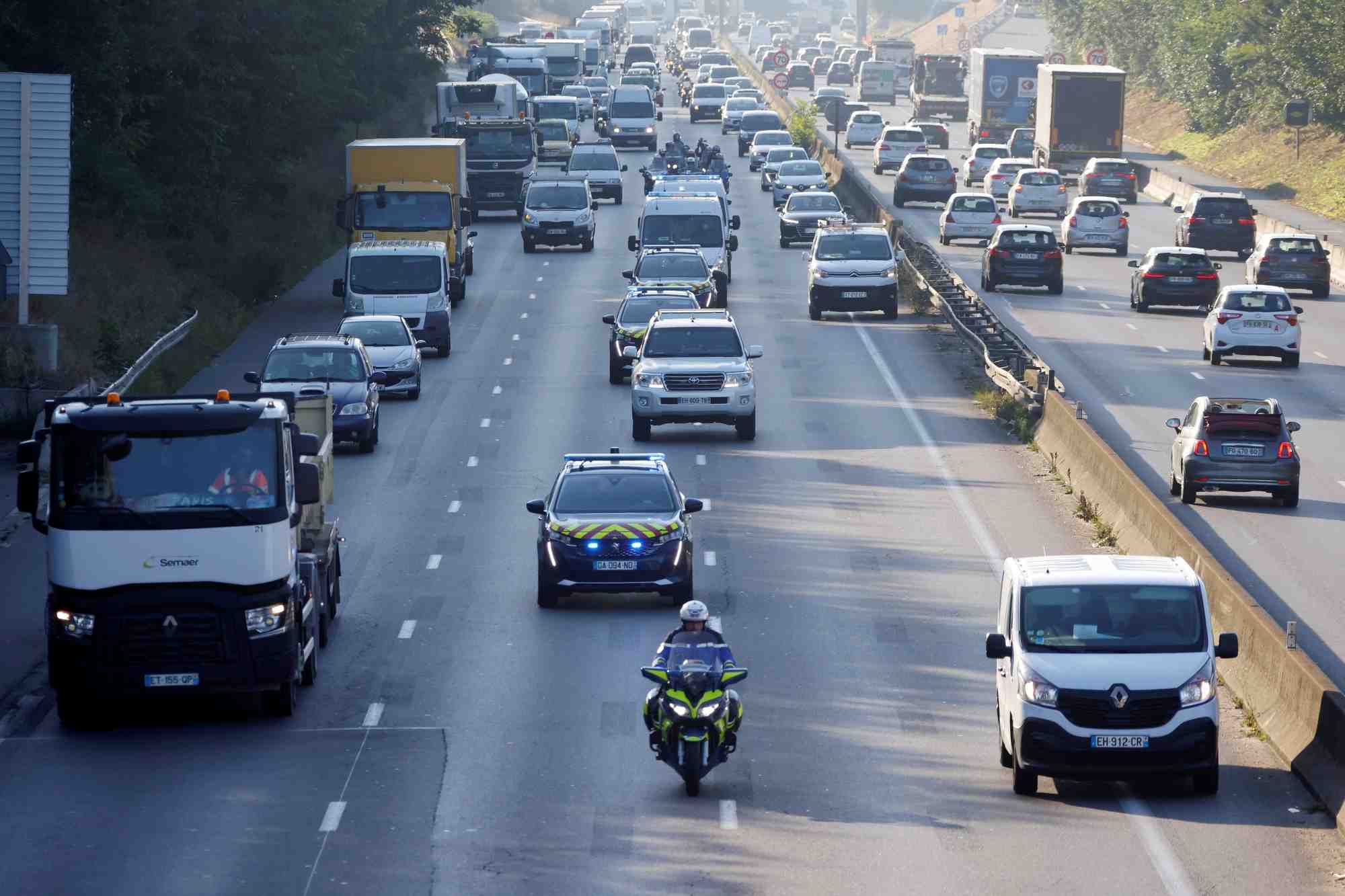 Un convoi de police et d'autres vehicules sur une autoroute pres de paris, france