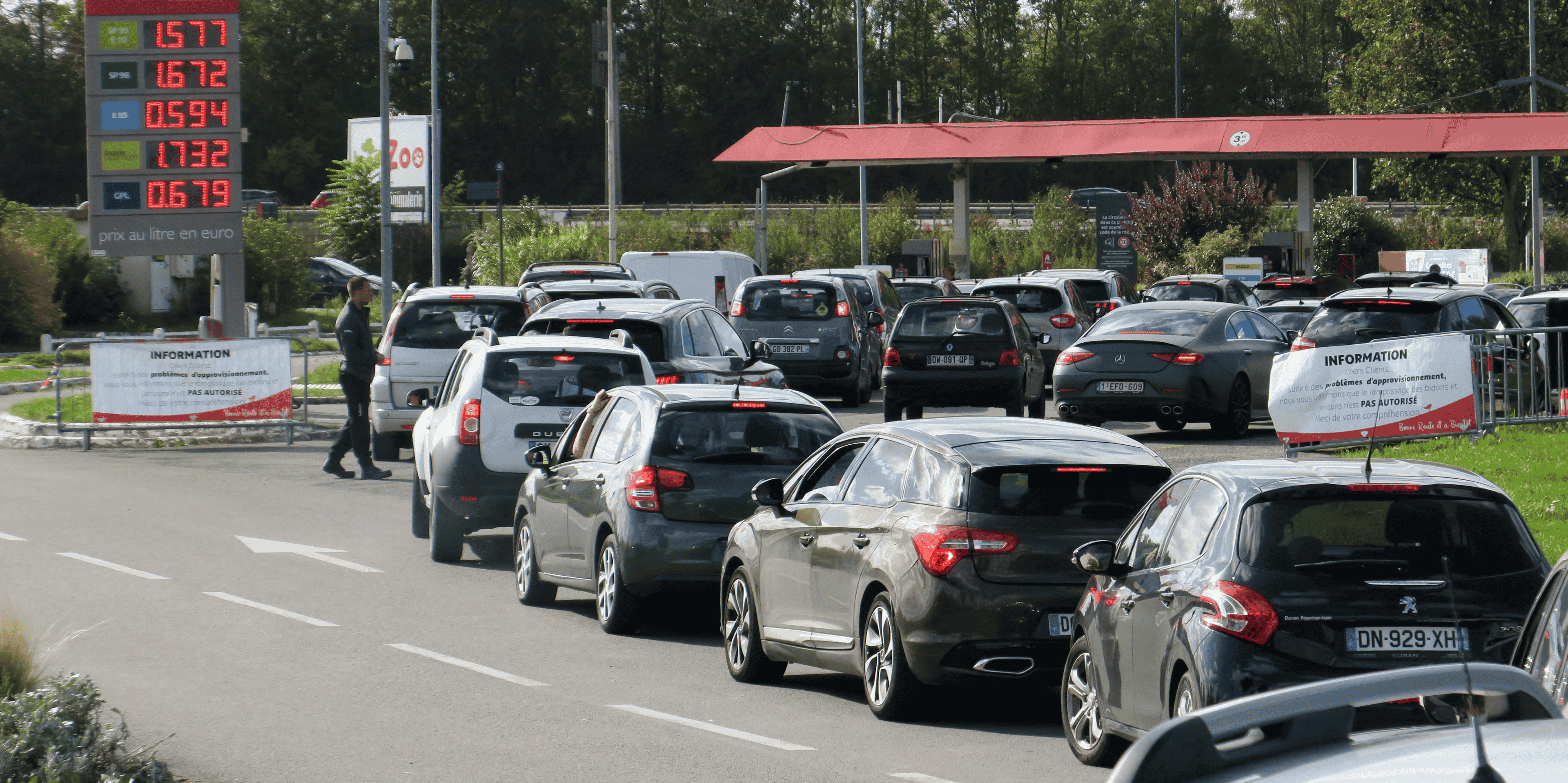 Des automobilistes font la queue pour remplir leur reservoir d'essence aux pompes de la station-service auchan de petite-foret