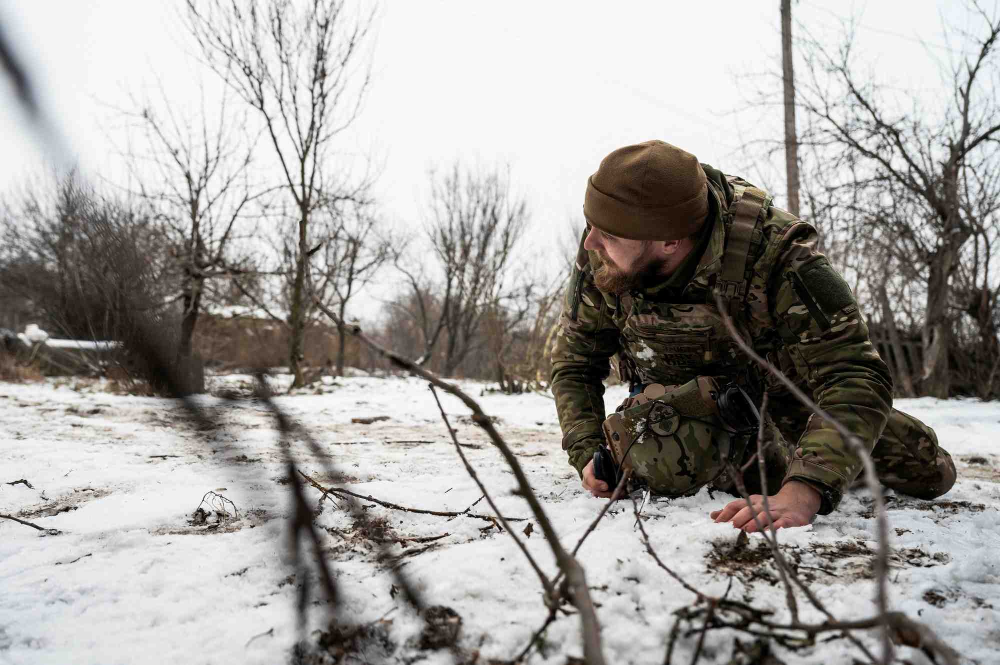 Un soldat ukrainien se couche pendant un bombardement des troupes russes sur la ligne de front dans la region de donetsk