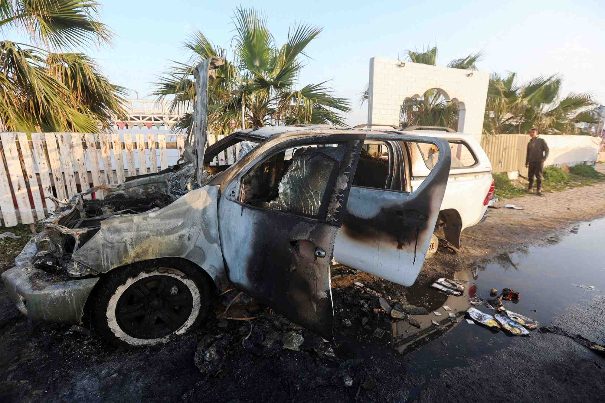 Une personne regarde un vehicule ou des employes de la world central kitchen (wck) ont ete tues dans une frappe aerienne israelienne