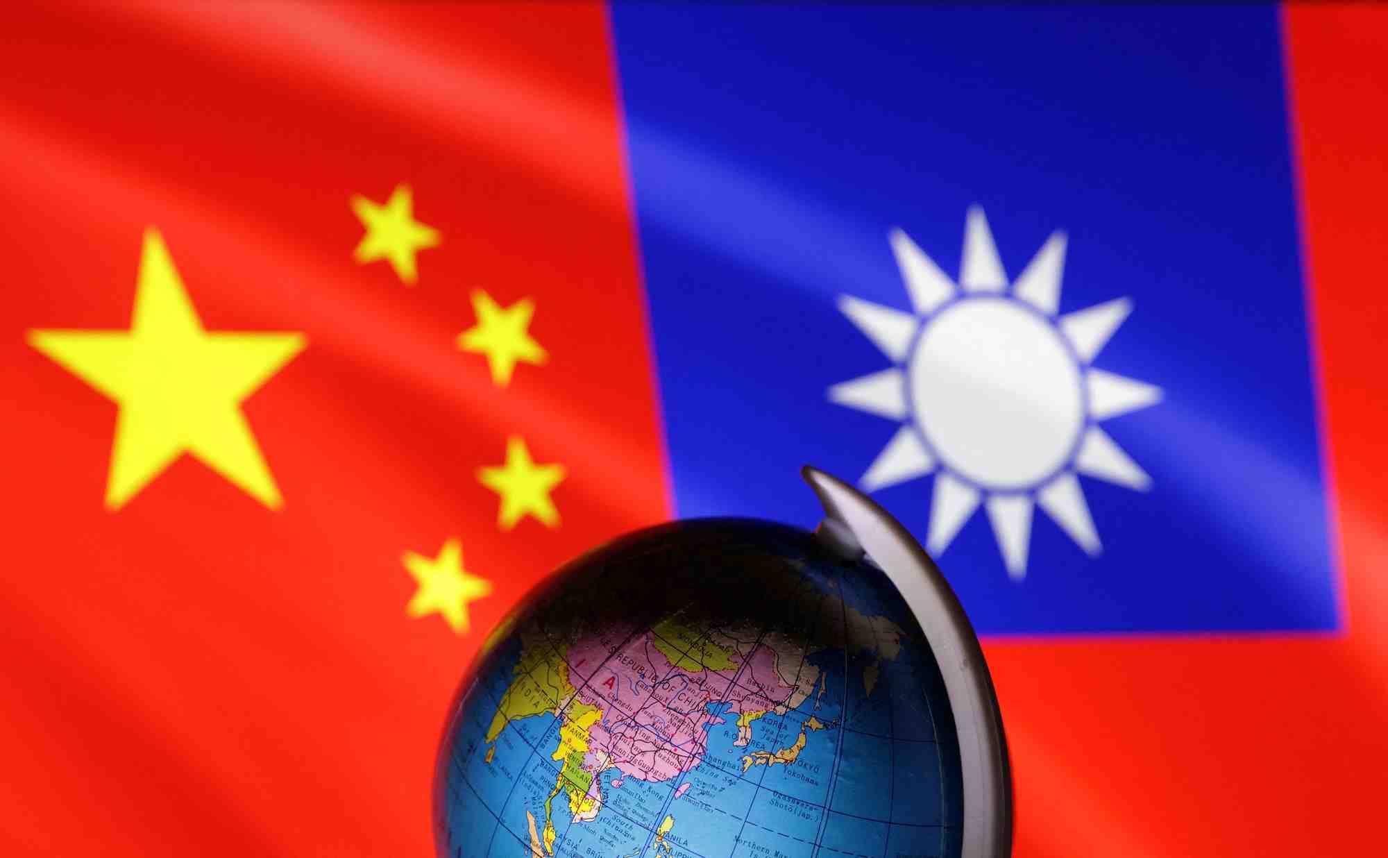 Un globe terrestre est vu devant des drapeaux chinois et taiwanais