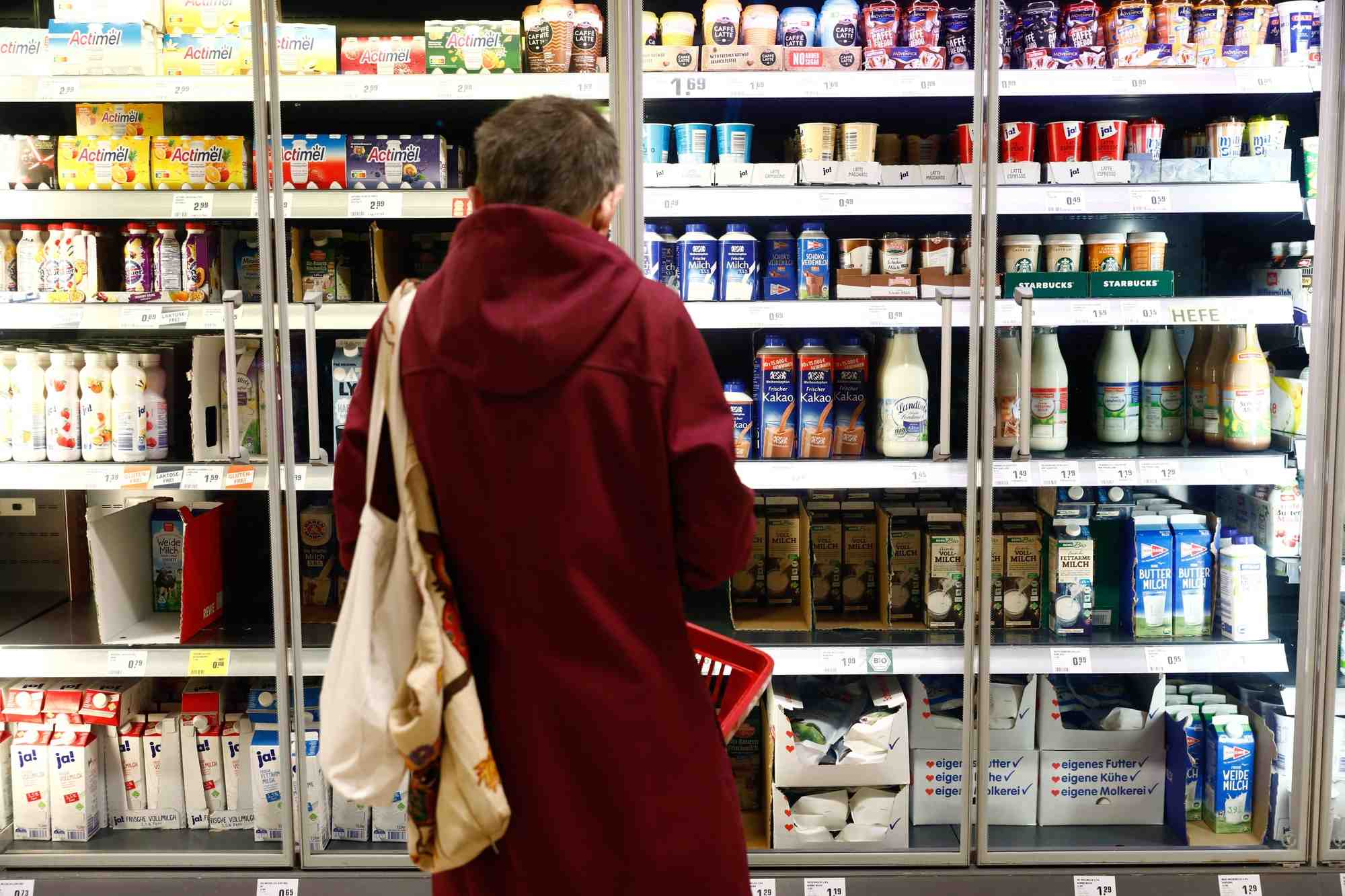 Un client regarde une etagere de produits laitiers dans un supermarche rewe a potsdam