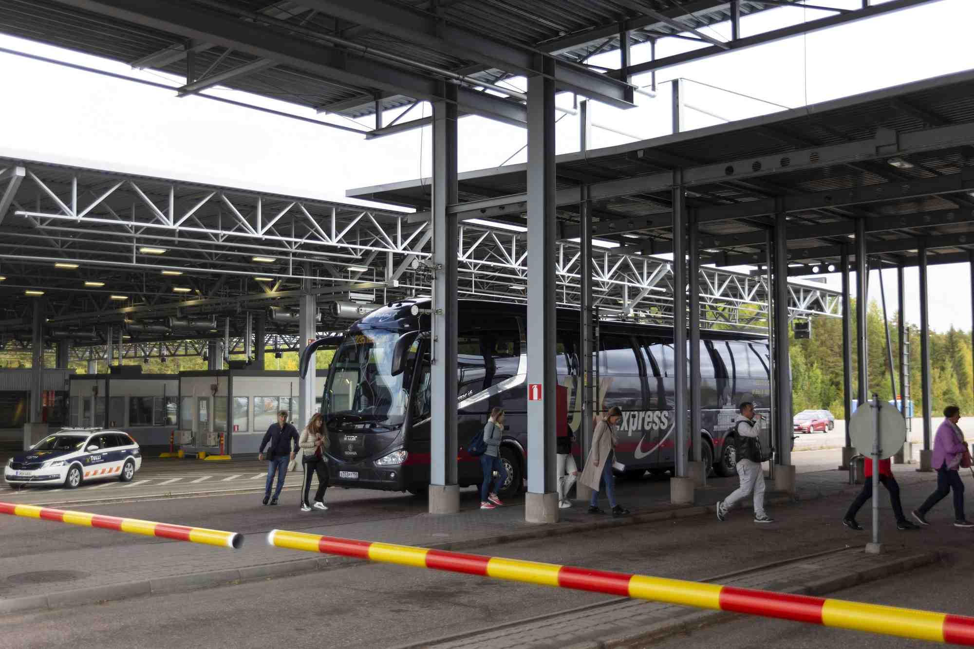 Des passagers sortent d'un bus au poste frontiere de vaalimaa