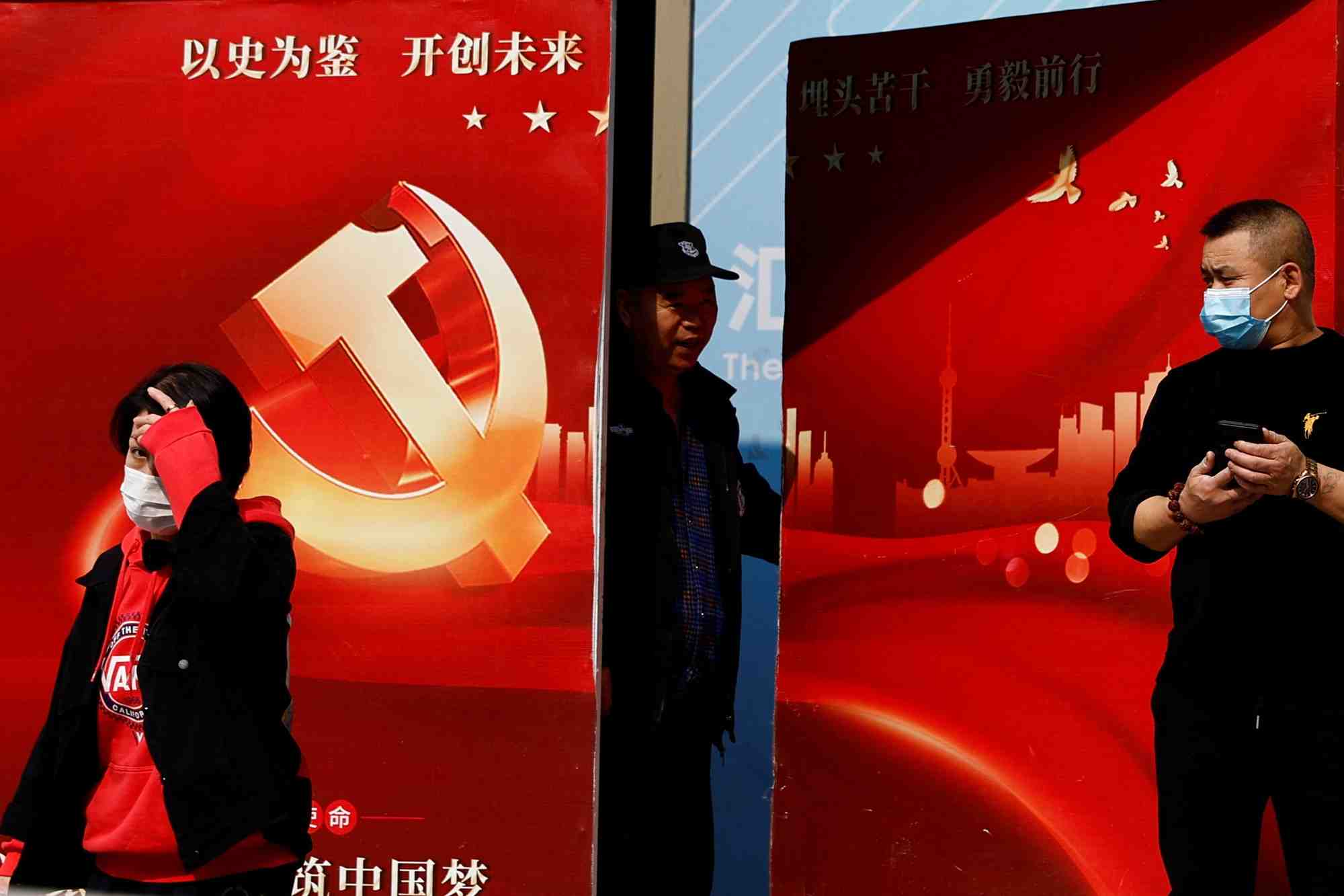 Un agent de securite ouvre une porte sur laquelle figure une affiche de bienvenue au 20e congres national du parti communiste chinois