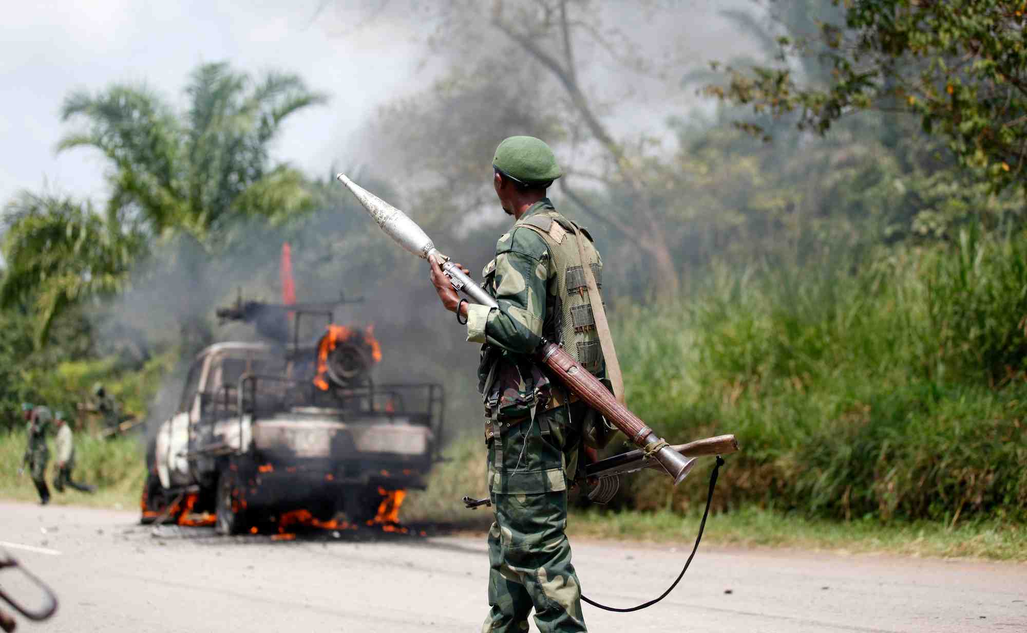 Un soldat congolais des forces armees de la republique democratique du congo (fardc) regarde son vehicule en feu
