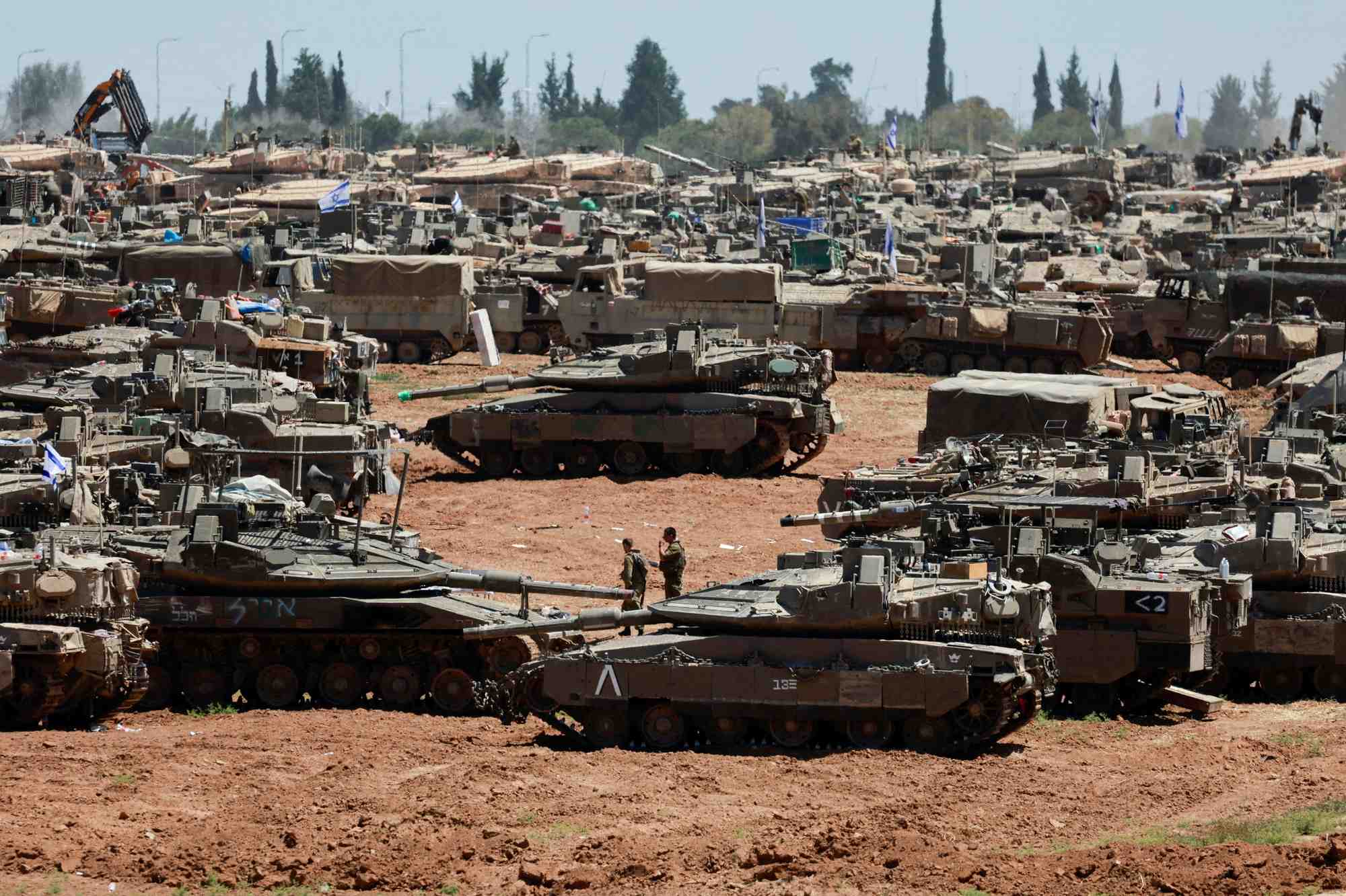 Des soldats israeliens passent devant des vehicules militaires pres de la frontiere entre israel et la bande de gaza