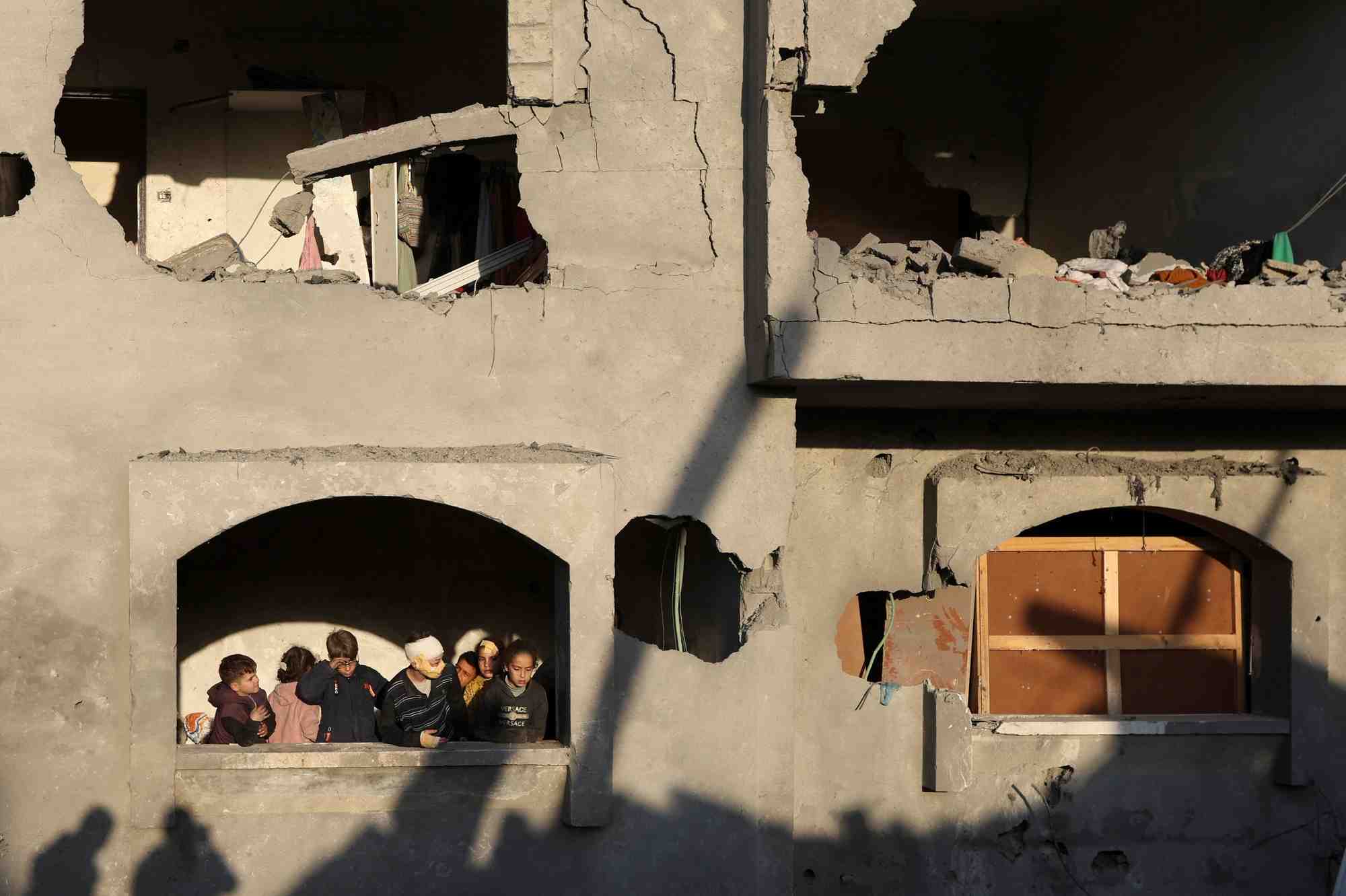 Les Palestiniens inspectent les dégâts sur le site d'une frappe israélienne sur une maison, au milieu du conflit Israël-Hamas, à Deir Al-Balah