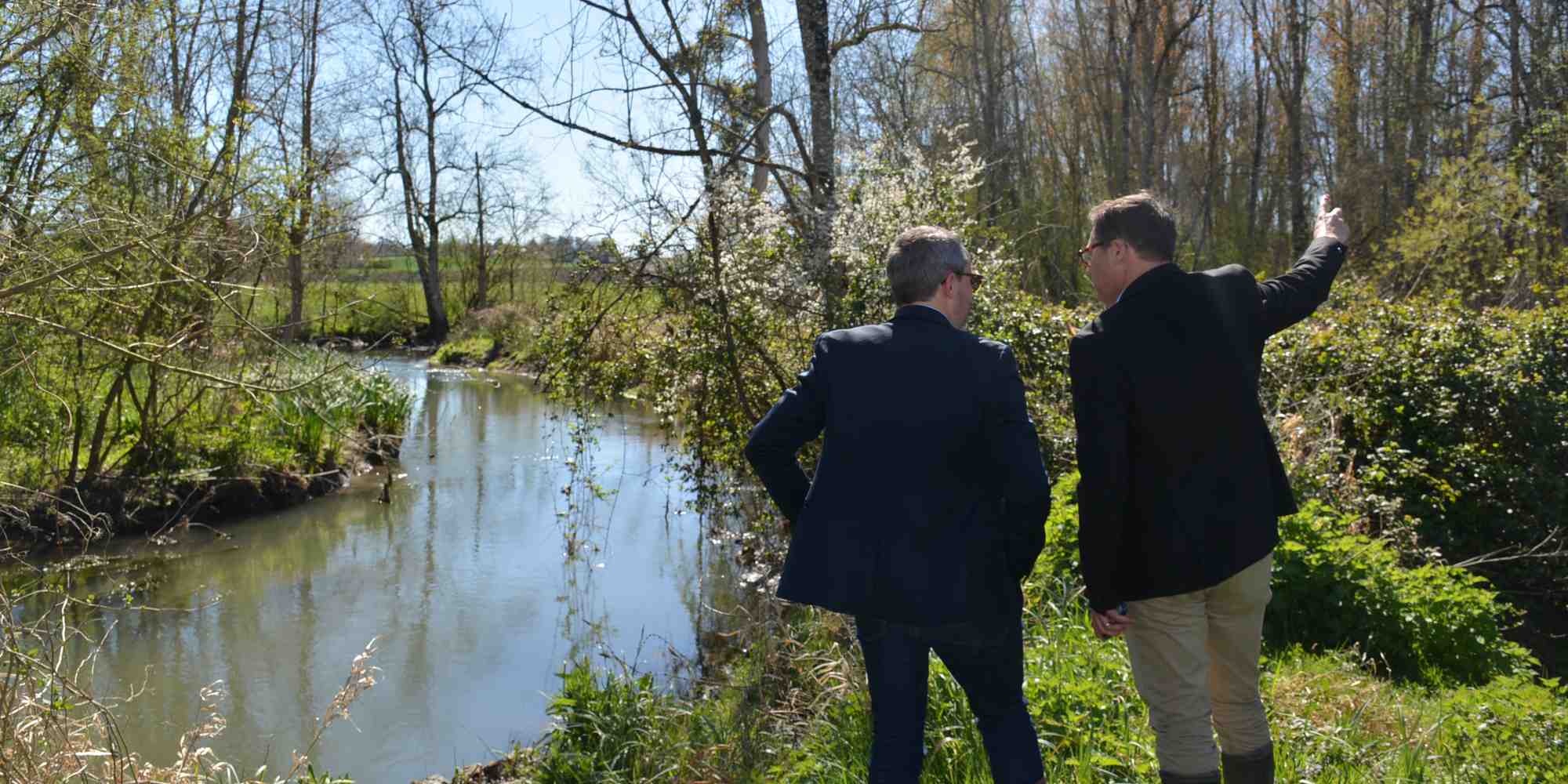 Des responsables de l'Agence de l'eau Adour-Garonne face à un méandre réaménagé sur le Trèfle, une rivière du bassin de la Charente.