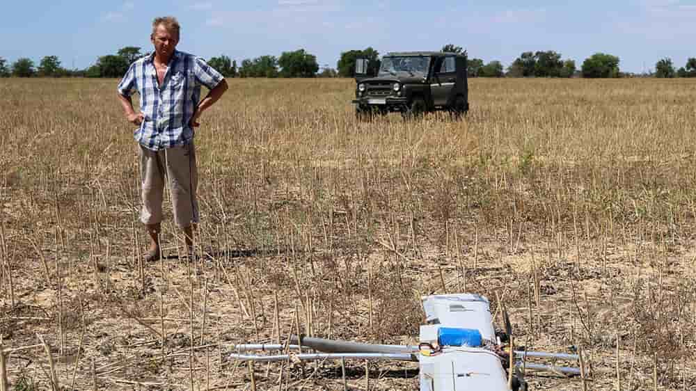 Juillet 2025, dans la région de Kherson : un fermier observe un drone tombé dans son champ.