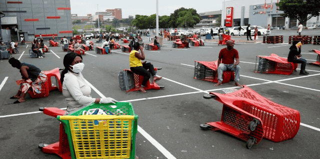 Des clients attendent leur tour devant une grande surface à Chatsworth près de Durban le 31 mars 2020, deux jours après le début de la période de 21 jours de confinement décrétée par les autorités de Pretoria.