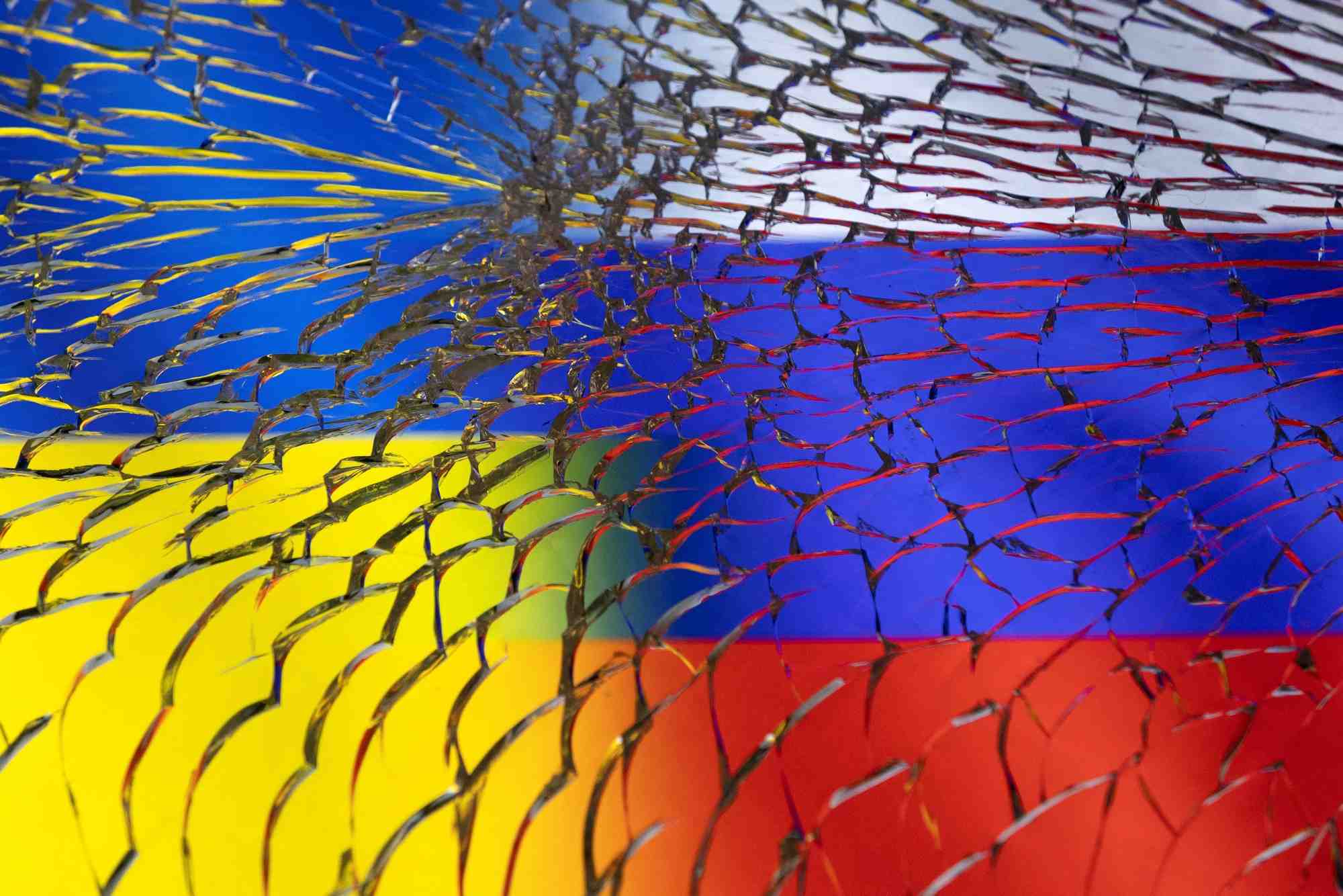 Llustration des drapeaux ukrainien et russe sous un verre brise