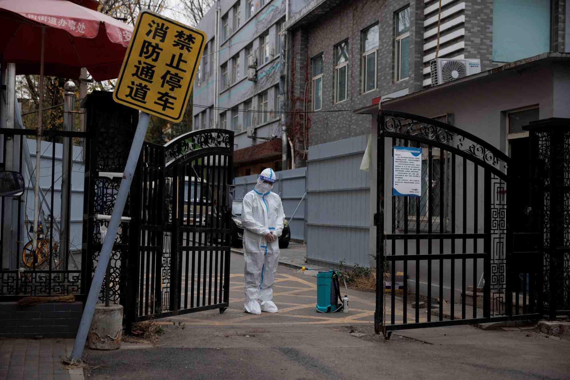 Un agent de prevention des epidemies monte la garde a l'entree d'un complexe residentiel a pekin, en chine