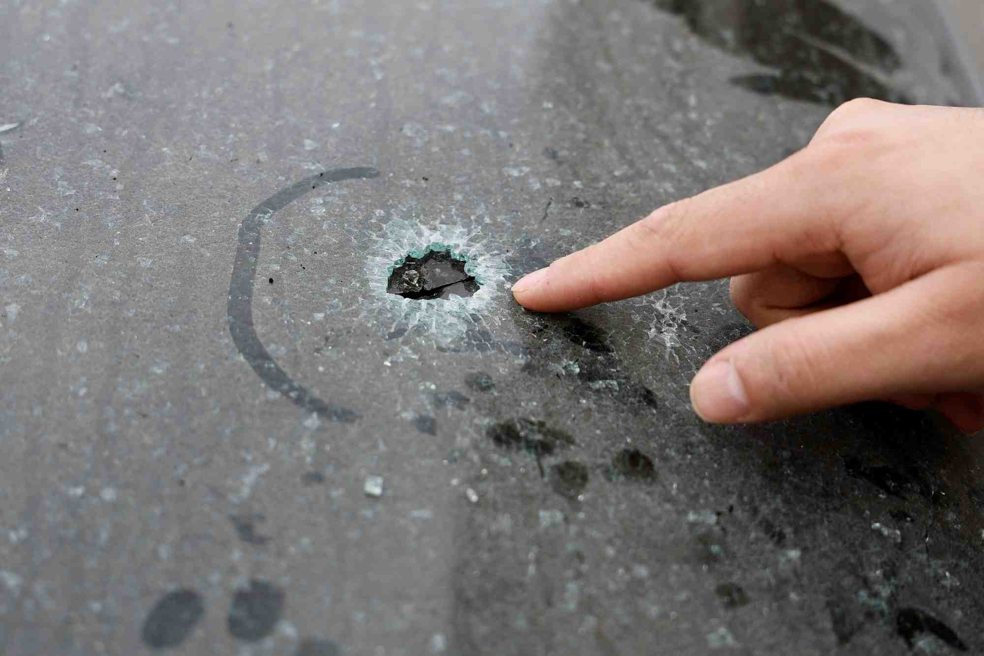 Un palestinien pointe du doigt un impact de balle dans sa voiture a houwara, en cisjordanie occupee par israel