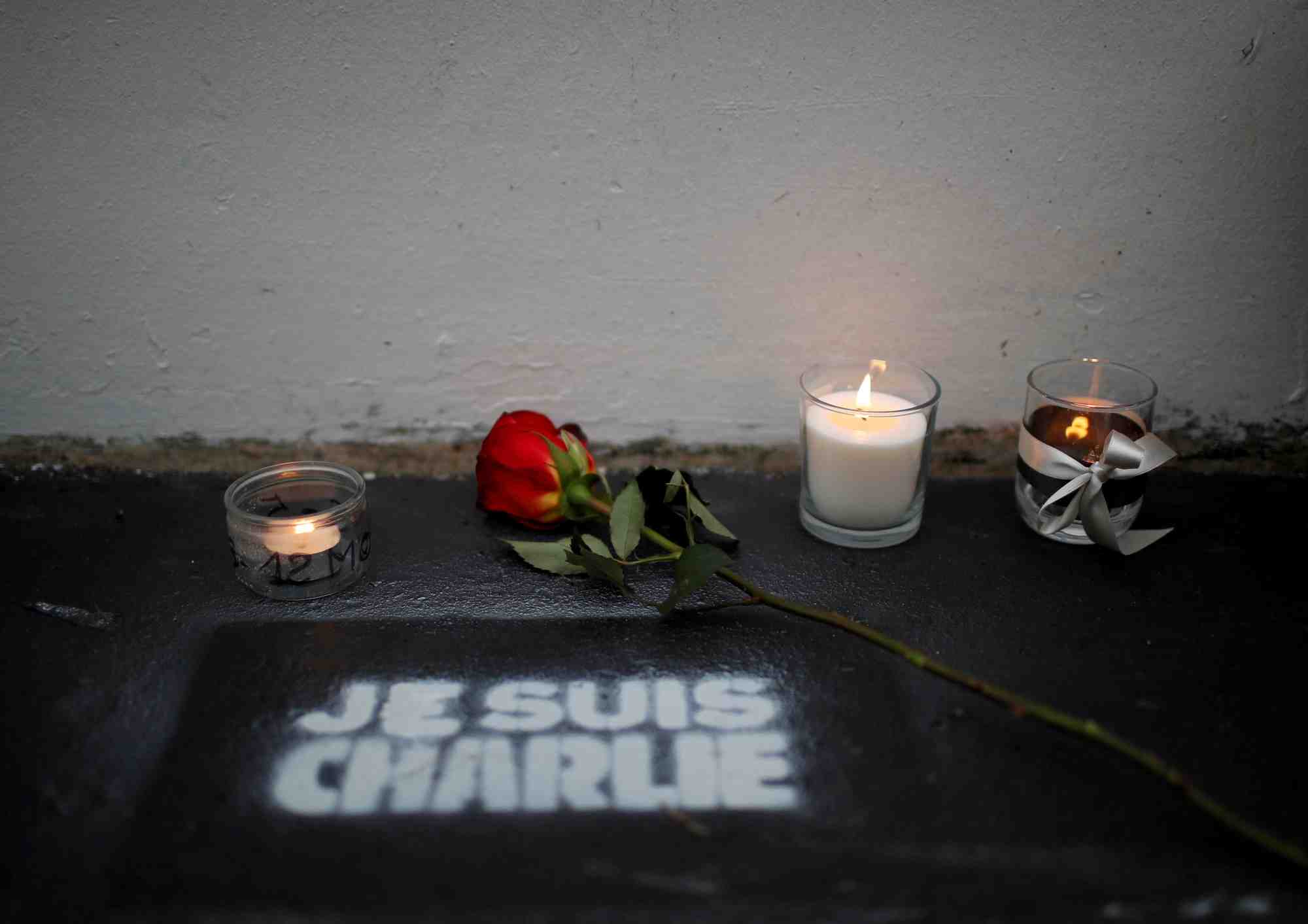 Des fleurs et des bougies devant l'ancien bureau du journal satirique charlie hebdo