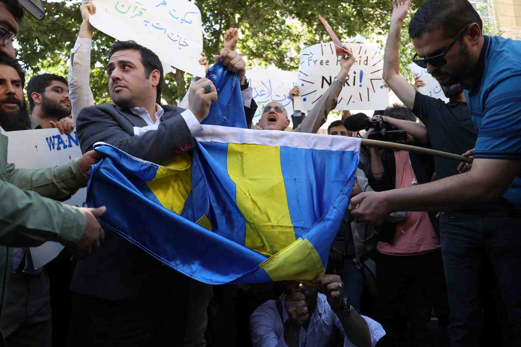 Des manifestants a teheran brulent le drapeau suedois lors d'une manifestation contre un homme qui a brule une copie du coran a stockholm