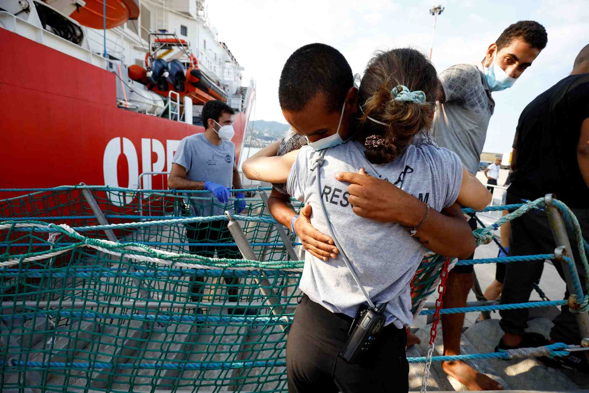Des migrants debarquent du bateau de sauvetage open arms apres leur arrivee au port de messine
