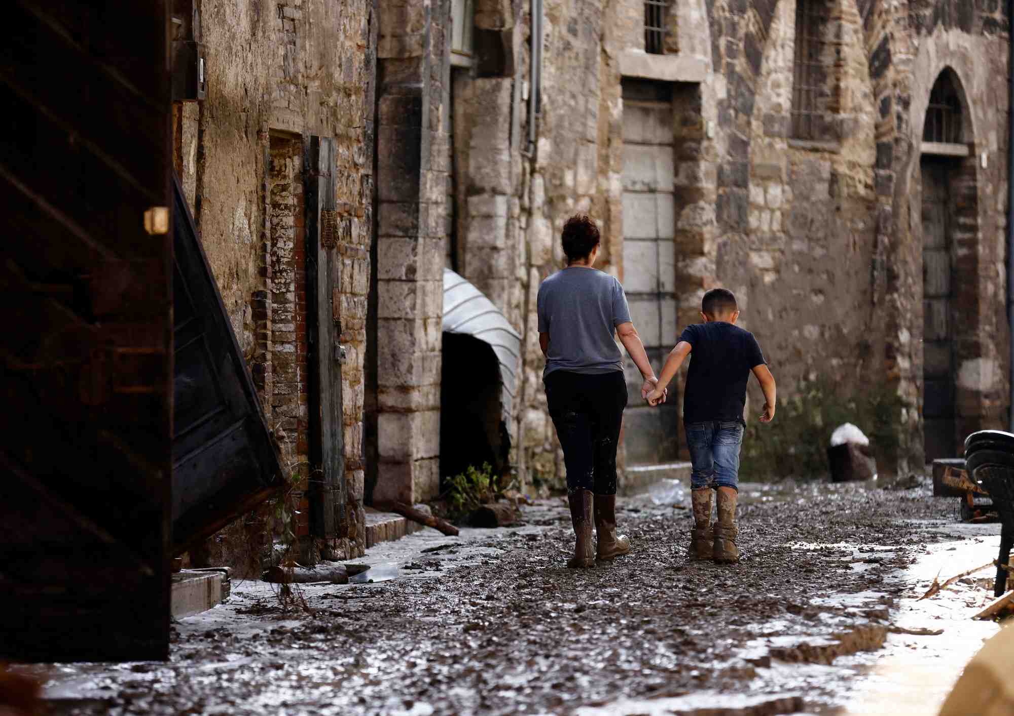 Une femme et un enfant marchent apres les inondations meurtrieres qui ont frappe la region centrale italienne des marches, a cantiano