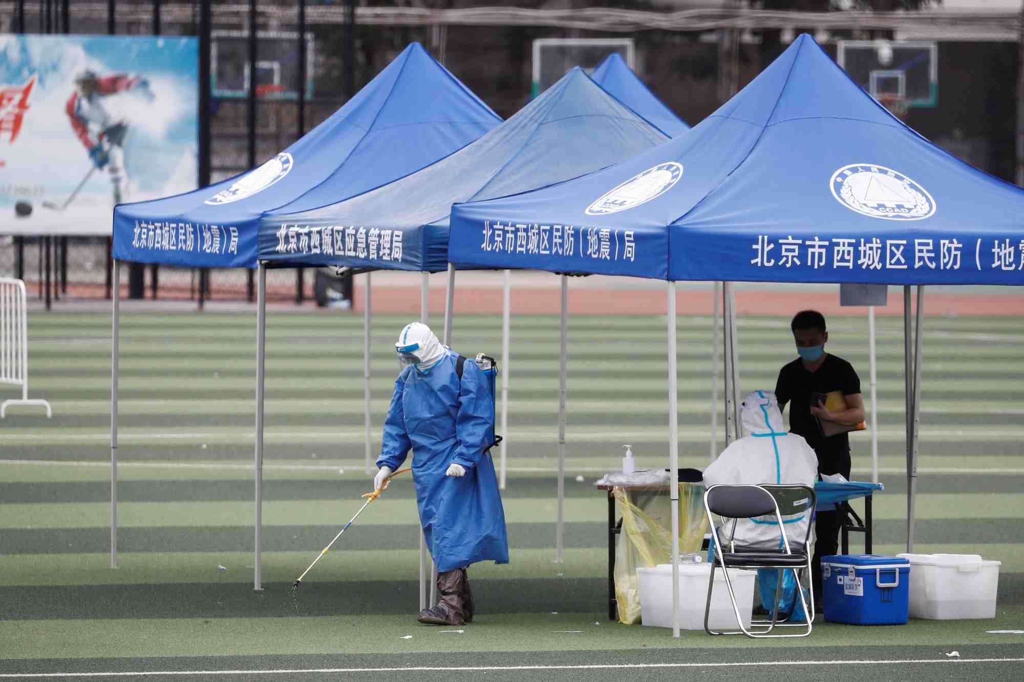 Pékin, Chine, coronavirus : un homme en tenue de protection diffuse du désinfectant au Guangan Sport Center