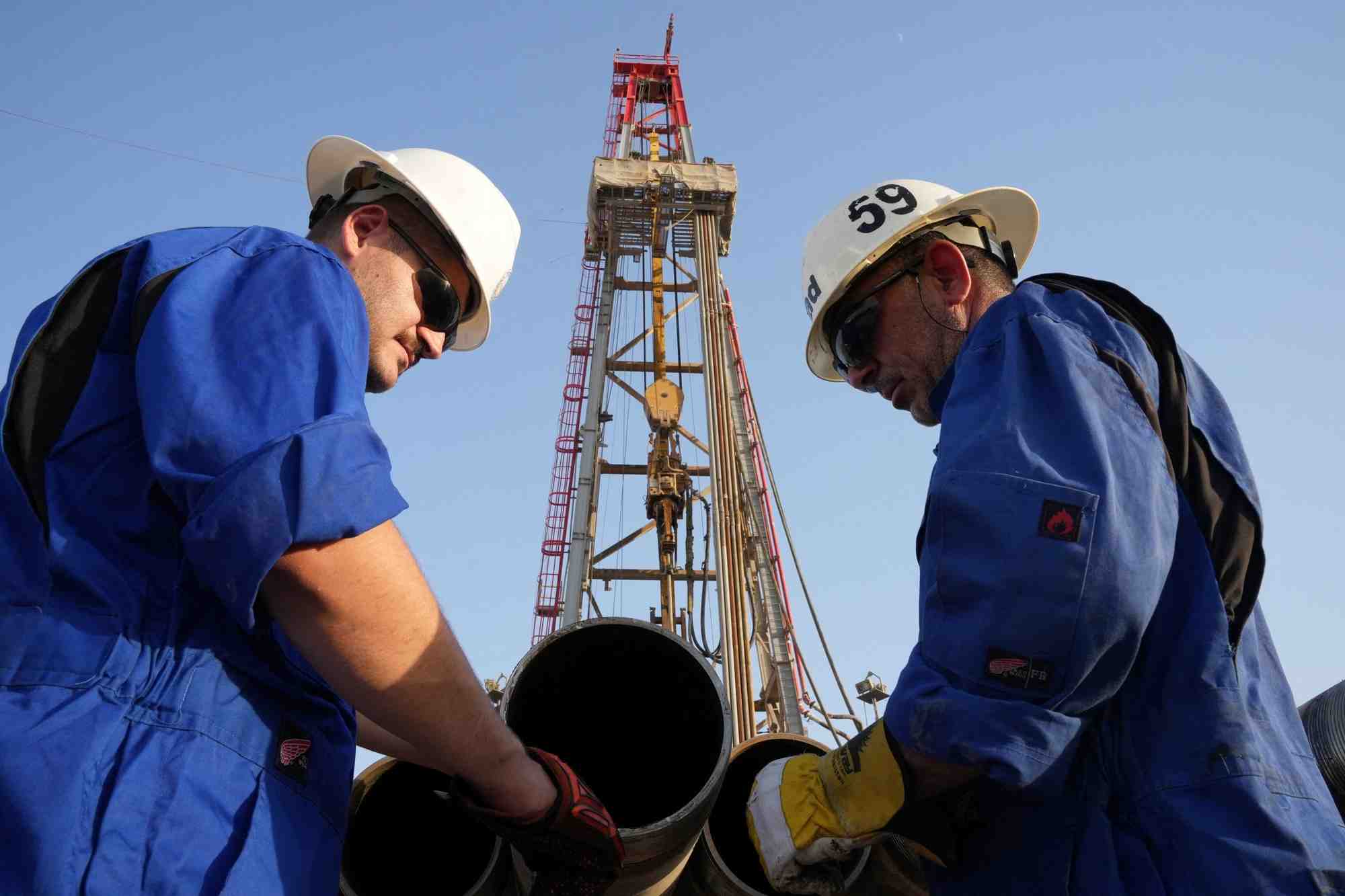 Des ouvriers travaillent sur un site de forage dans un champ petrolifere, en irak