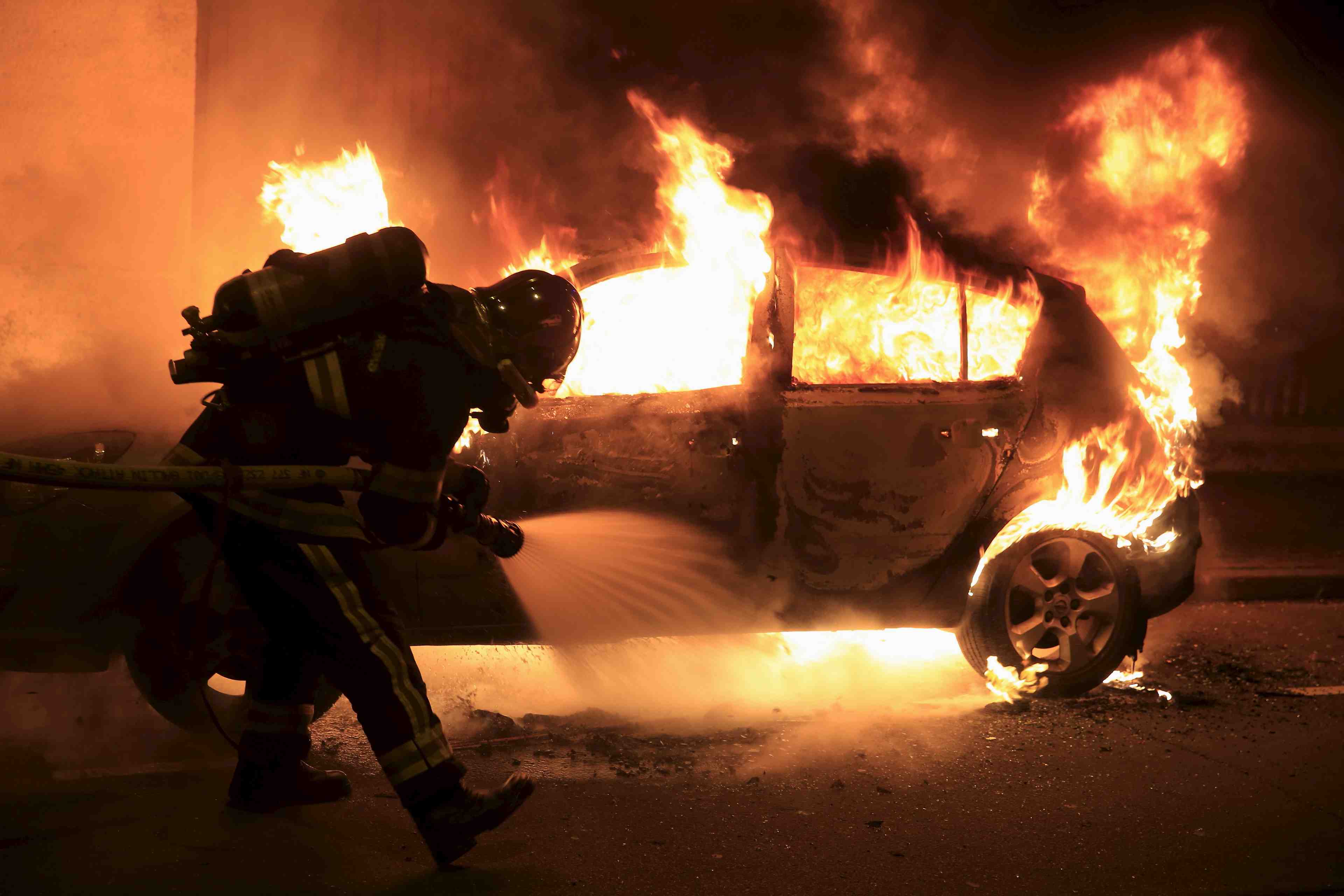 Firefighters extinguish a burning car during new year celebrations in lille, northern france