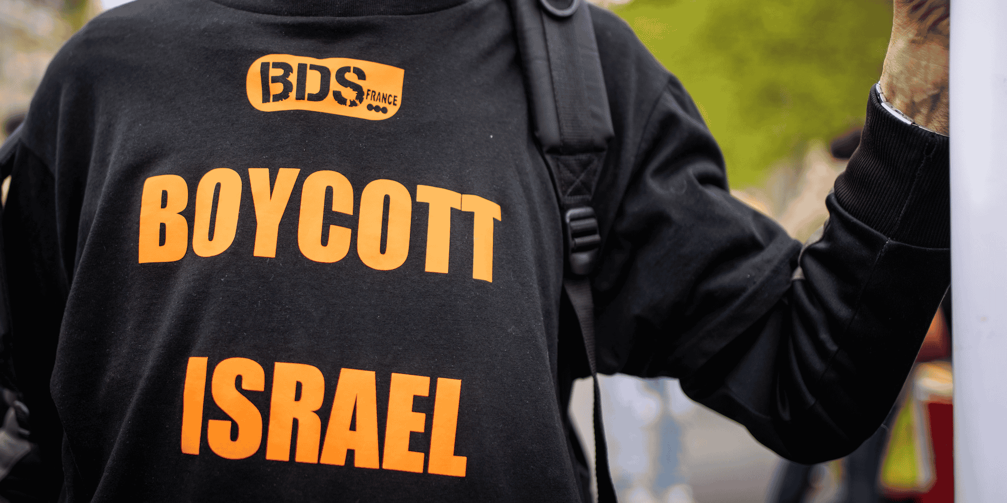 Manifestation antiraciste à Paris le 29 avril 2023 contre le projet de loi d'asile et immigration et contre l'opération Wuambushu d'expulsion des sans papiers à Mayotte. Un manifestant arbore un t-shirt avec le message BDS France. L'action BDS (Boycott Desinvestissement Sanctions) a été lancée par la société civile palestinienne en 2005, suite a des dizaines d'années de lutte contre Israël et sa politique de colonisation des territoires occupés.