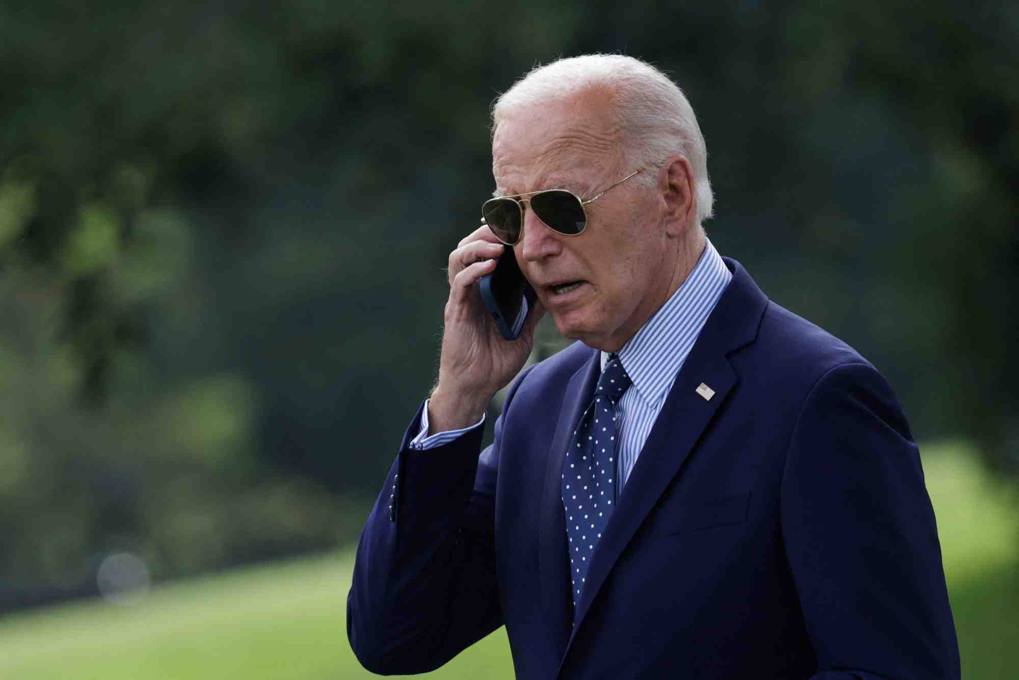 Le president americain joe biden parle au telephone dans le jardin de la maison blanche