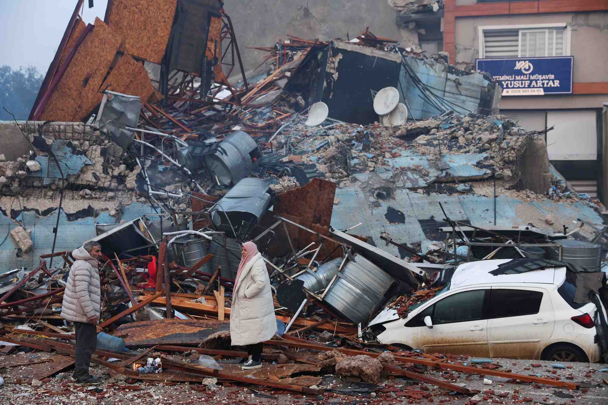 Des gens regardent les decombres et les degats a la suite d'un seisme a hatay, en turquie. /photo prise le 7 fevrier 2023/reuters/umit bektas