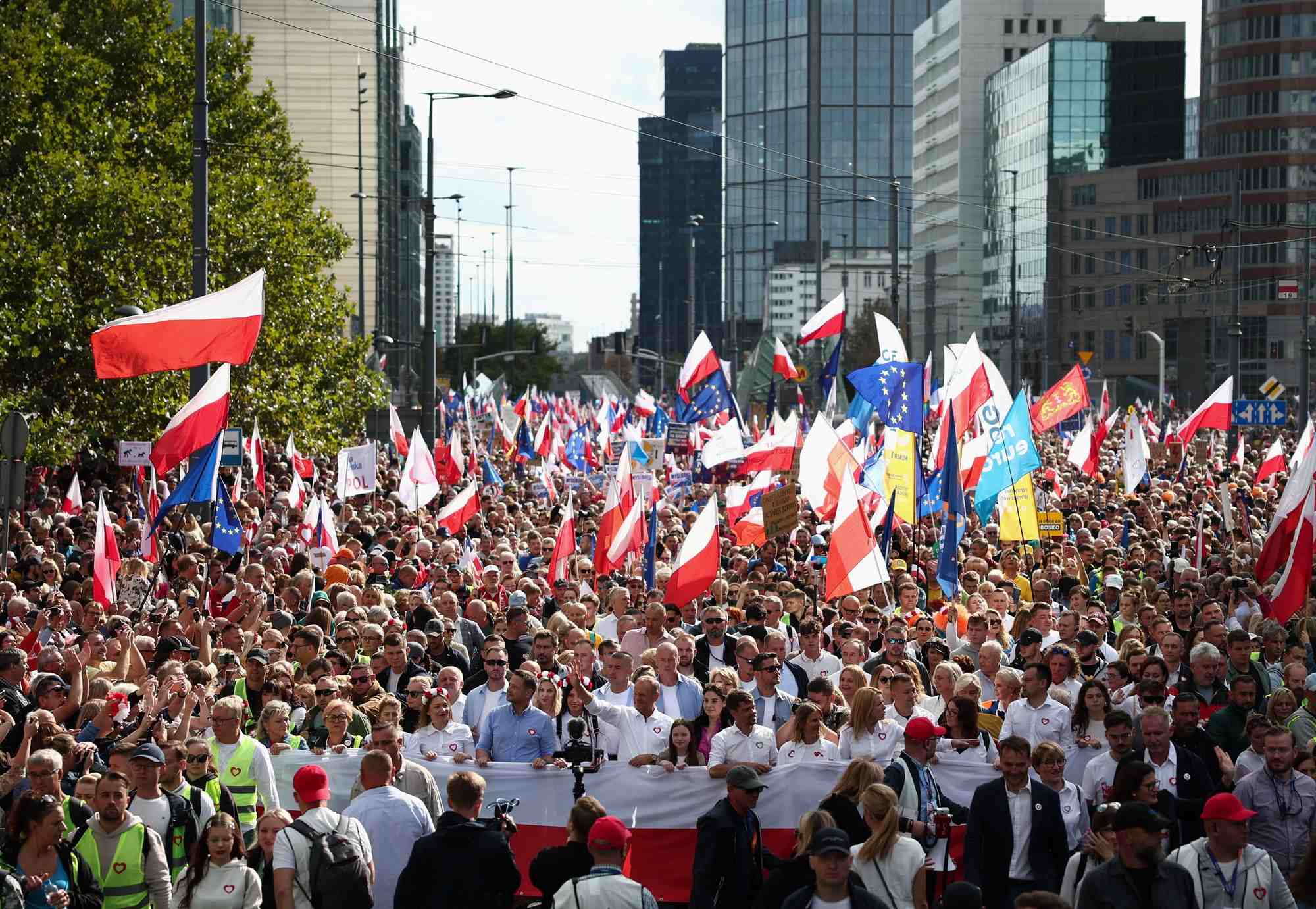 Donald tusk, chef de file de plateforme civique (po), le plus grand parti d'opposition en pologne, et rafal trzaskowski, le maire de varsovie, marchent devant le drapeau national polonais a varsovie