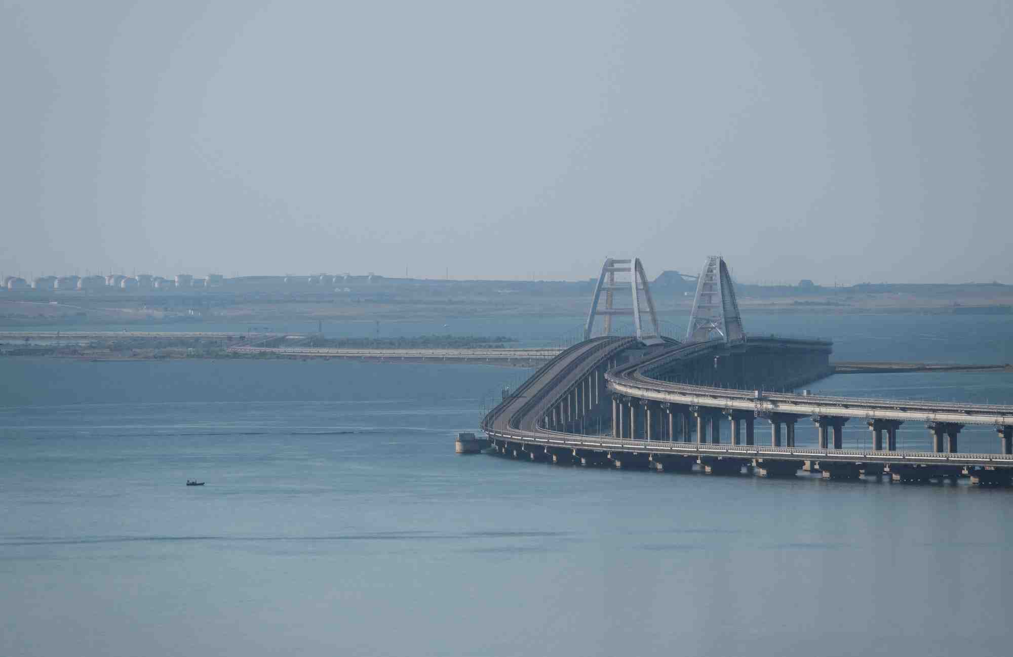 Un bateau navigue a cote du pont de crimee qui relie le continent russe a la peninsule de l'autre cote du detroit de kertch