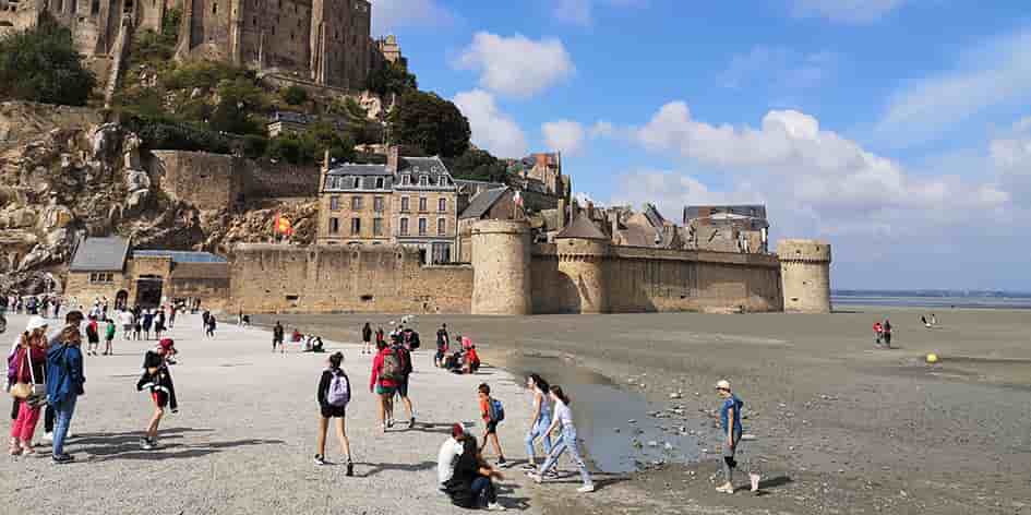 Pour accéder au Mont-Saint-Michel, les visiteurs empruntent un pont-passerelle sur pilotis qui redonne au site touristique son caractère maritime.