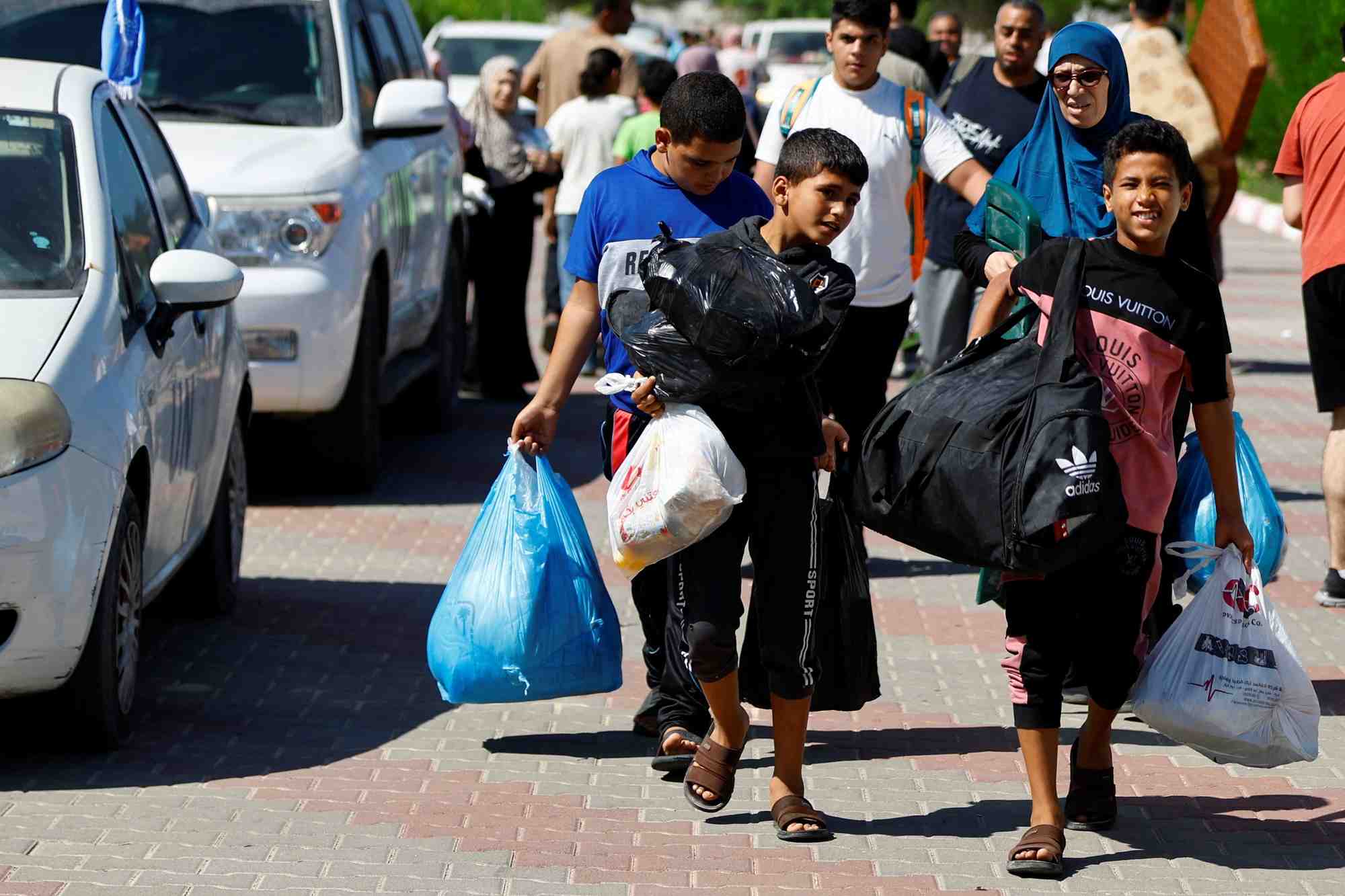 Photo des familles de membres du personnel d'organisations internationales transportent leurs affaires pour se refugier dans un centre des nations unies apres que l'unrwa a annonce avoir transfere son centre d'operations central au sud de la bande de gaza