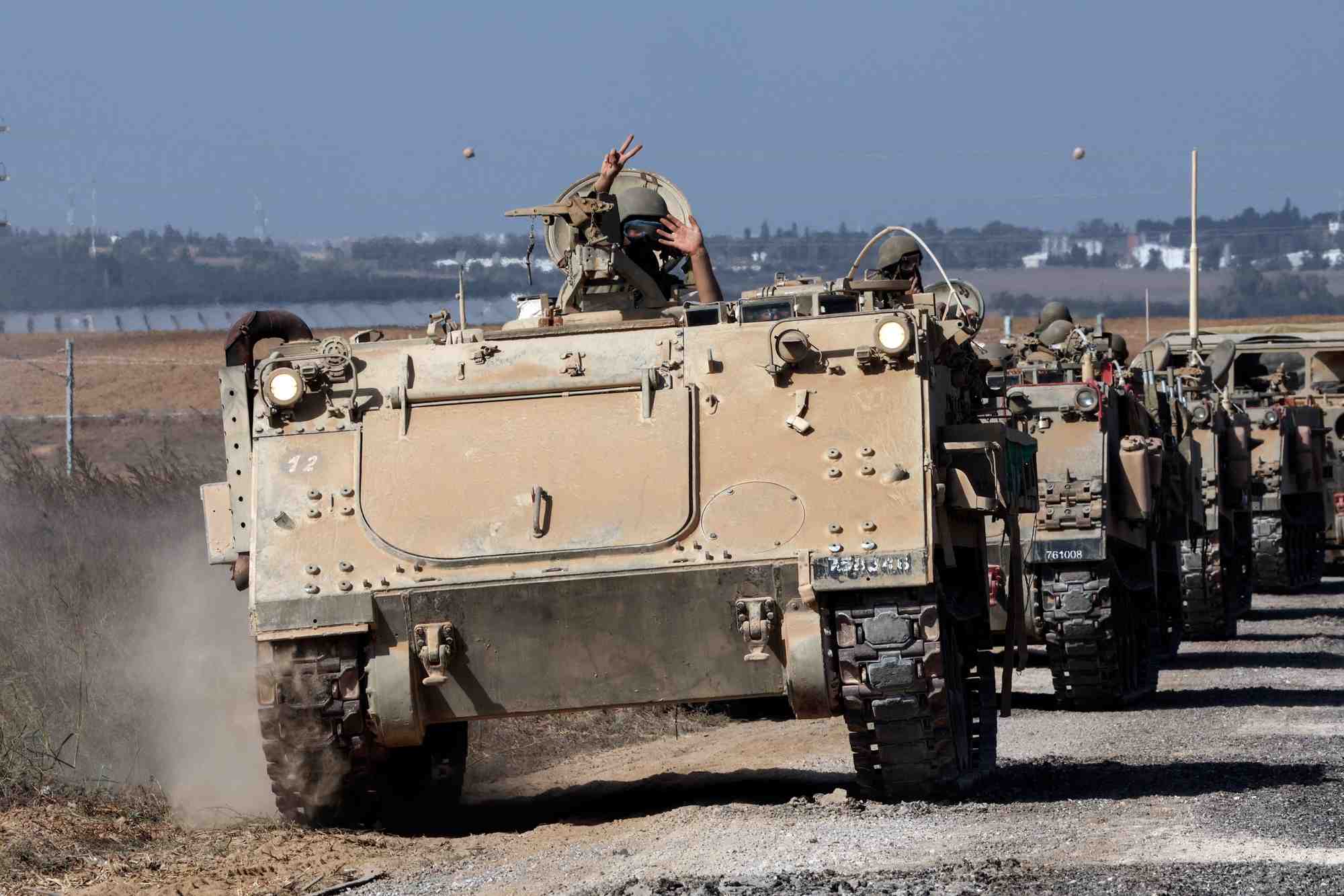 Un convoi de vehicules blindes de transport de troupes prend position pres de la frontiere entre israel et la bande de gaza