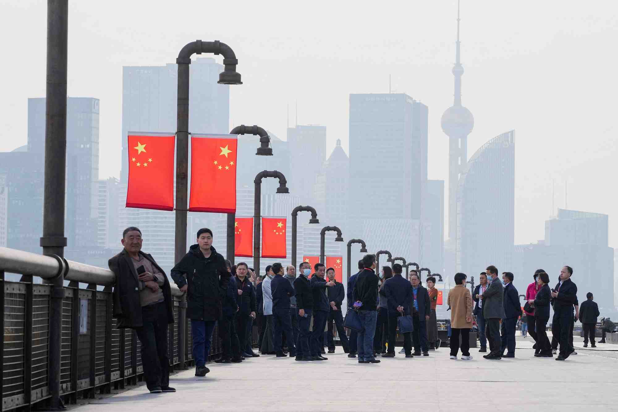 Des personnes visitent une rive devant le quartier financier de lujiazui, pendant le congres national du peuple (cnp) a shanghai
