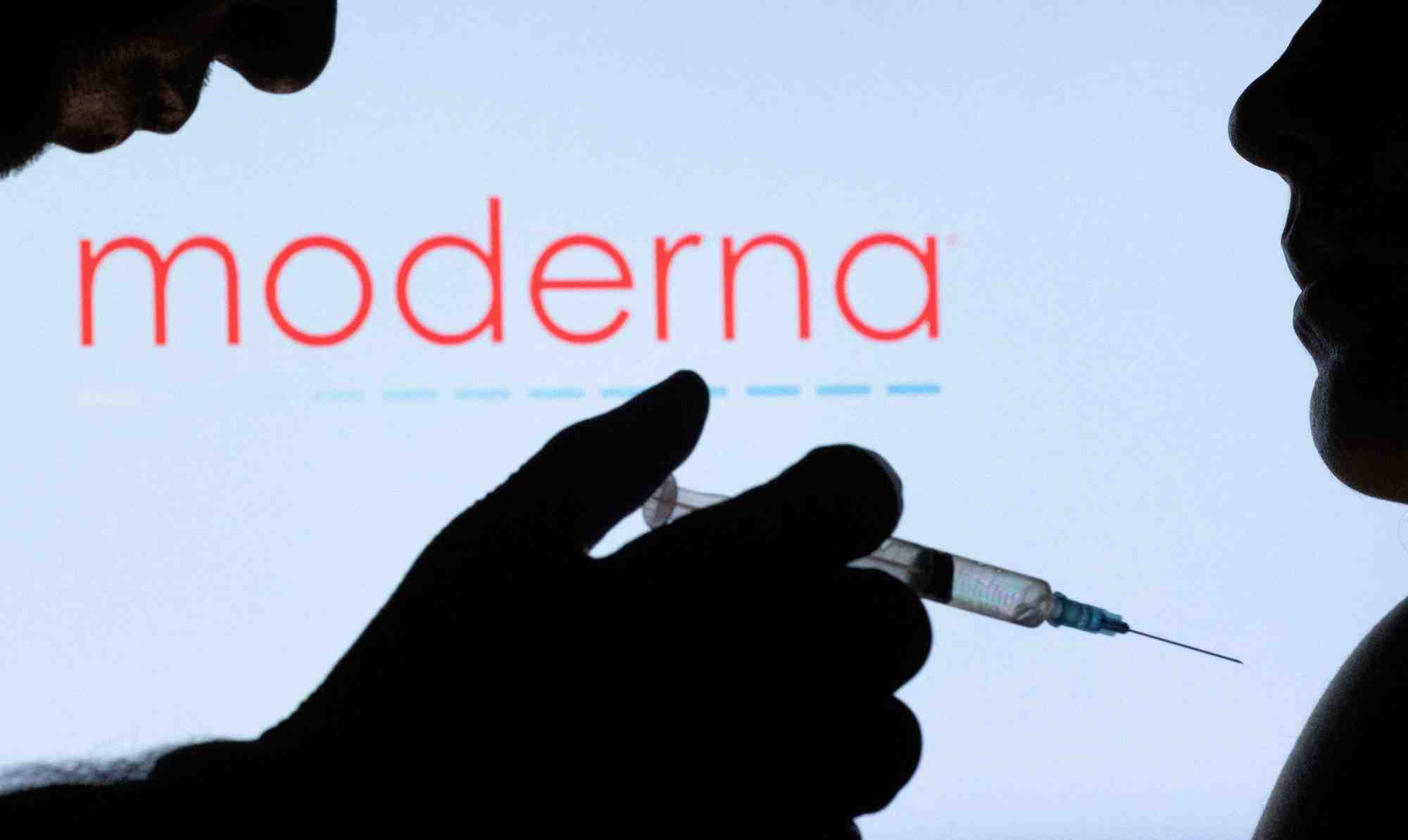 Des personnes posent devant le logo moderna