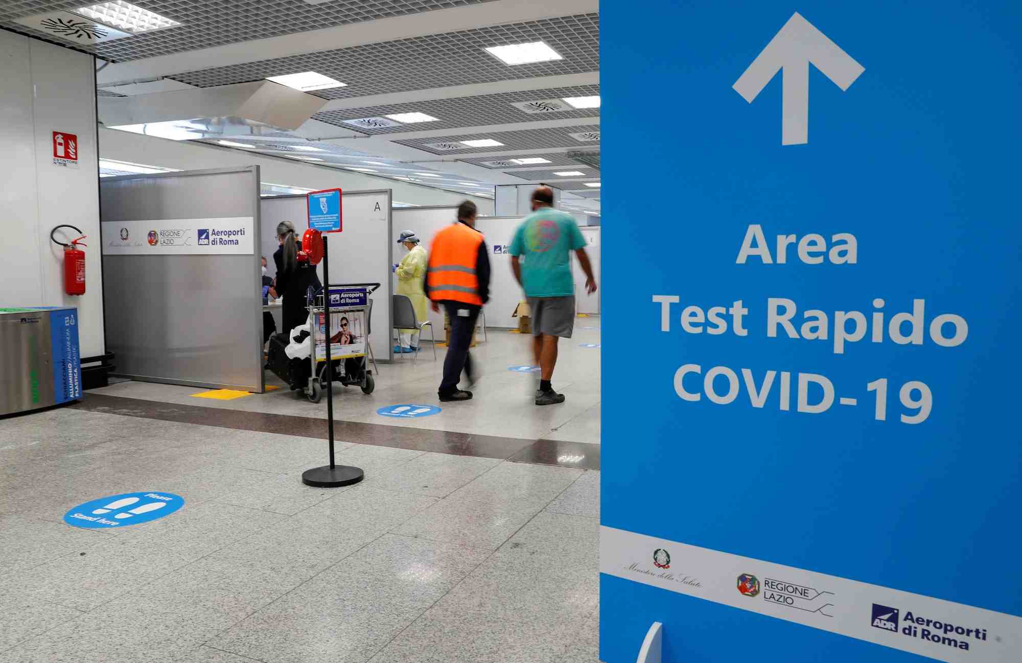 Des personnes marchent a cote d'un site de tests de depistage du covid-19 a l'aeroport de fiumicino