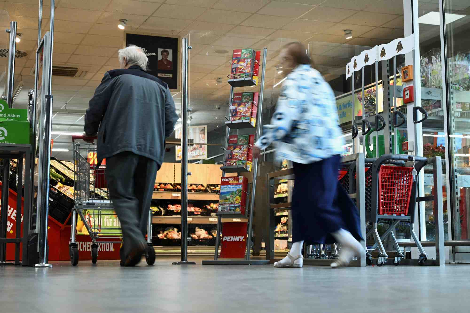 Des personnes passent devant un stand faisant reference a la campagne europeenne "couts reels" menee chaque semaine par le supermarche discount penny a berlin