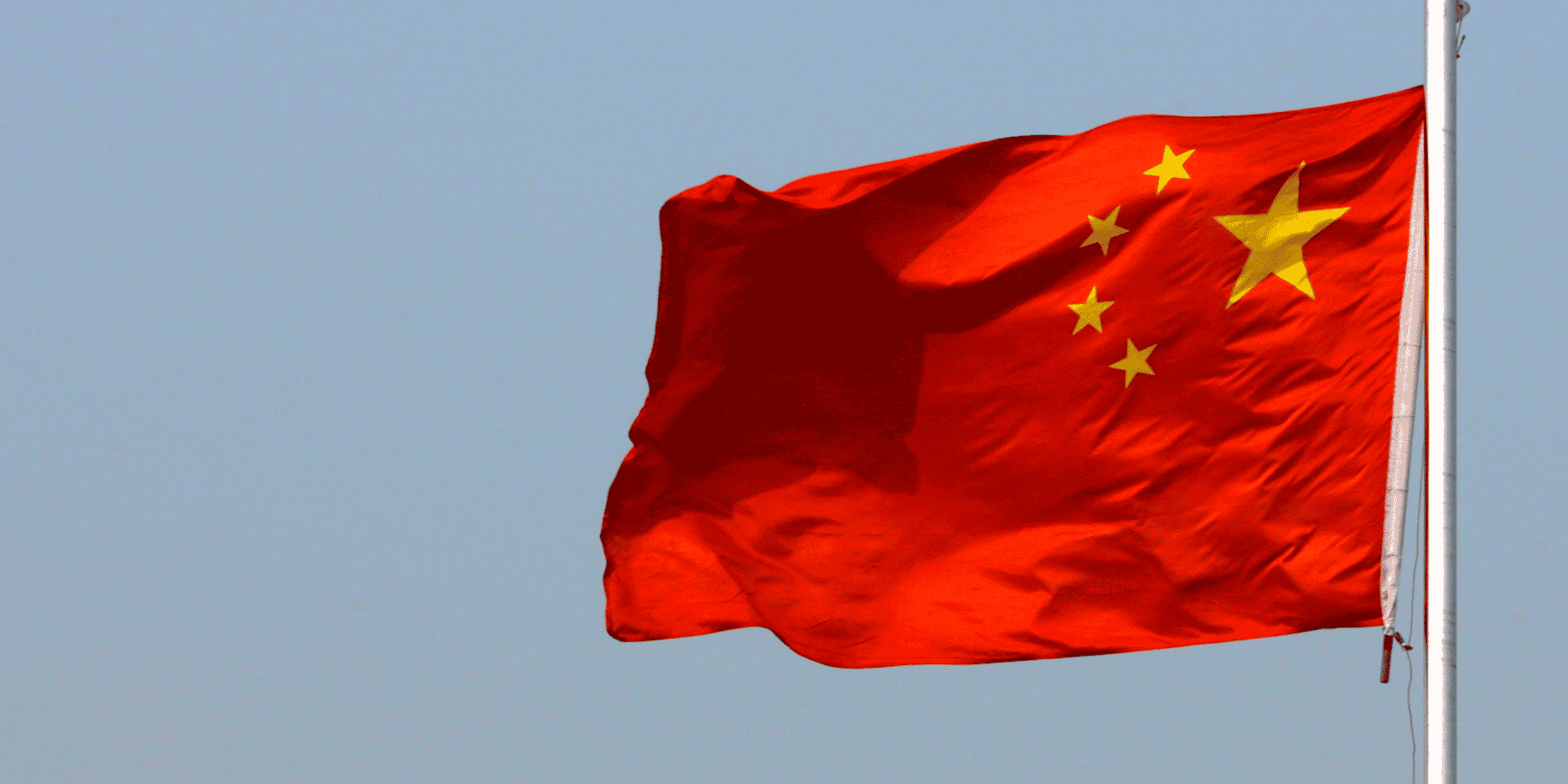 Un drapeau chinois flotte devant la grande muraille de chine, situee au nord de pekin
