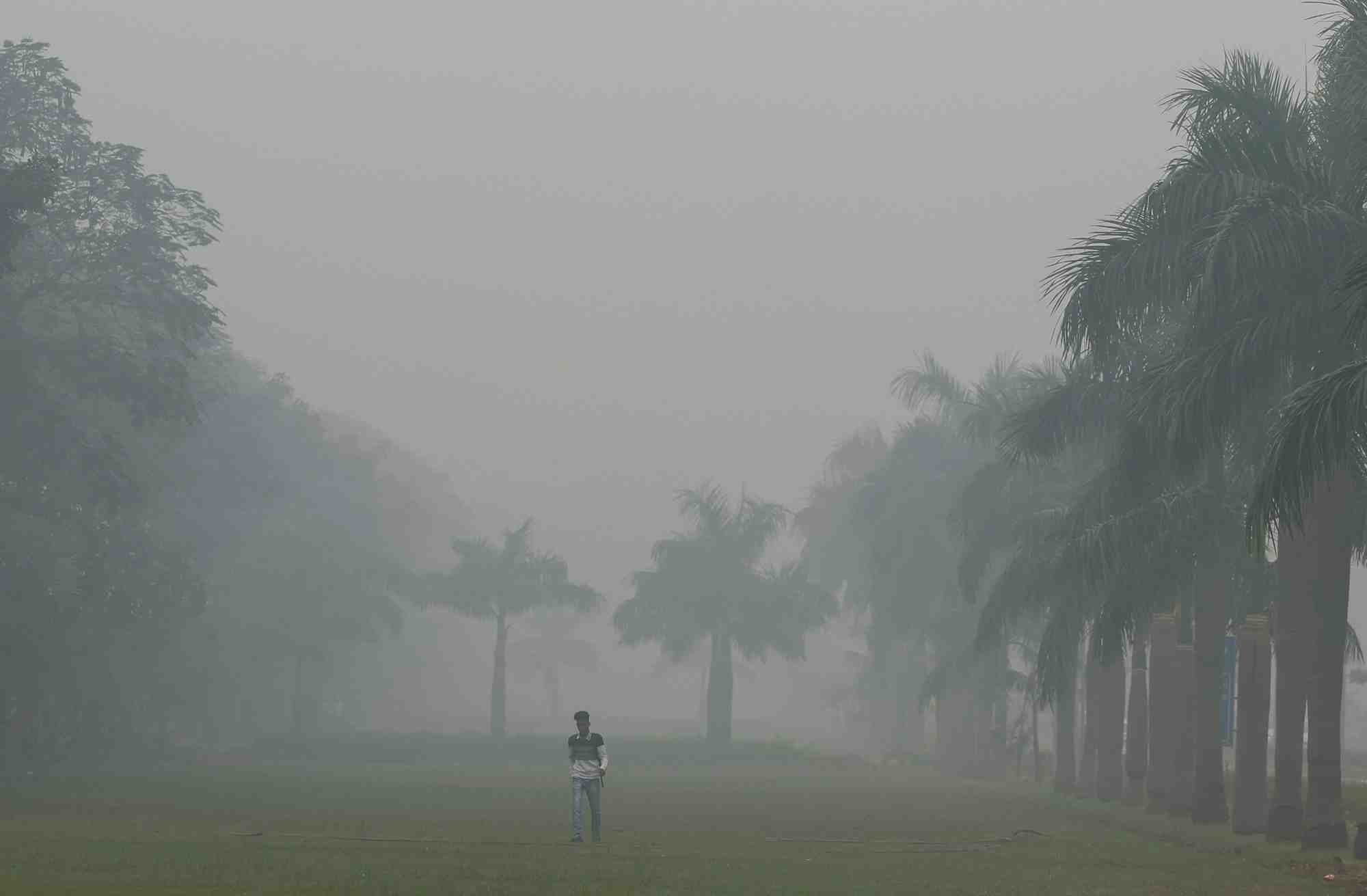 Un homme marche dans le brouillard a new delhi