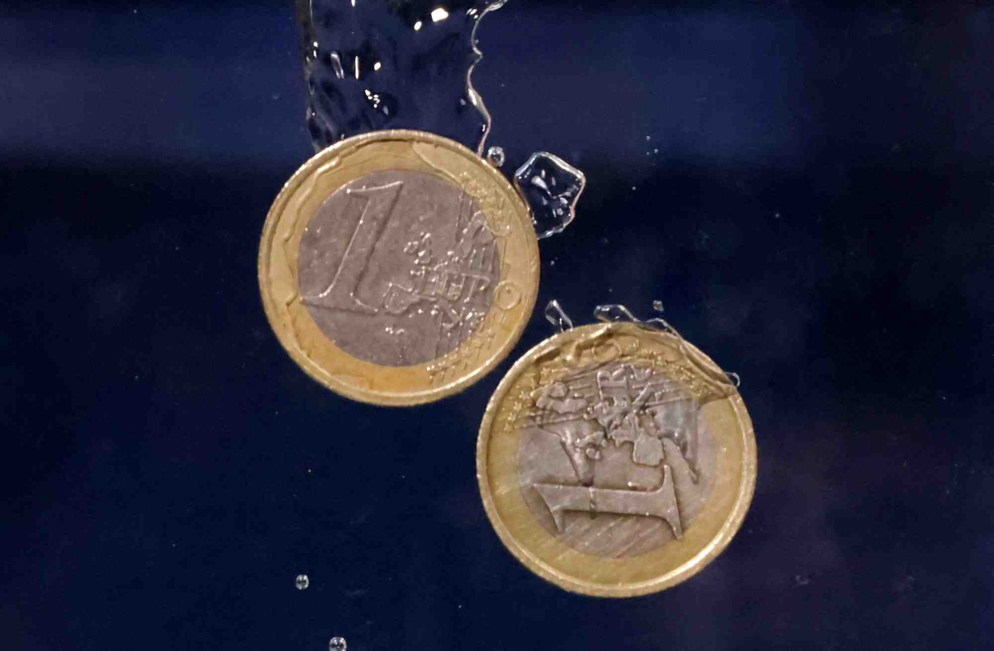 Des pieces en euros plongent dans l'eau