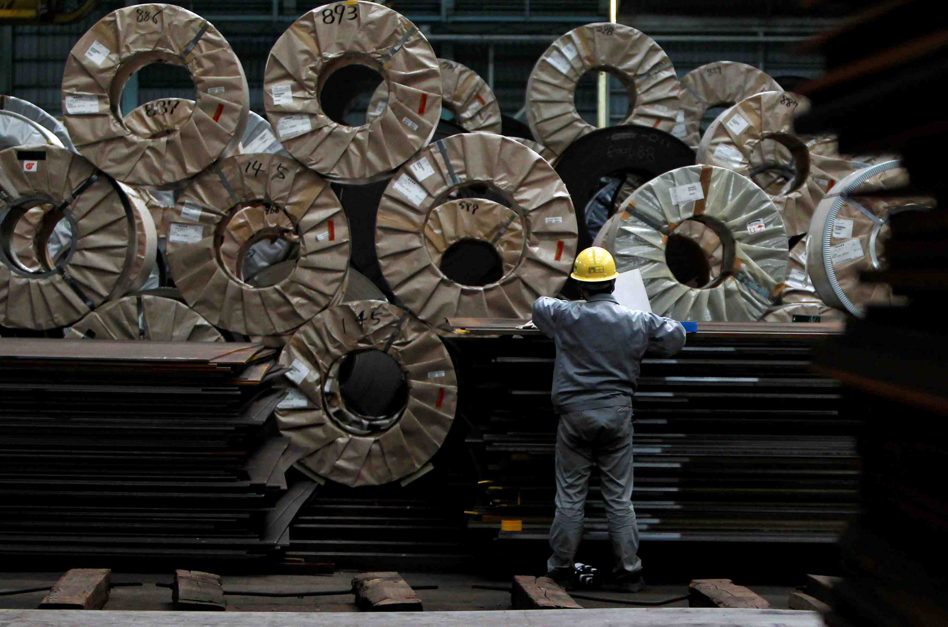 File photo - a worker checks steel coils and steel sheets at a distribution warehouse in urayasu, east of tokyo