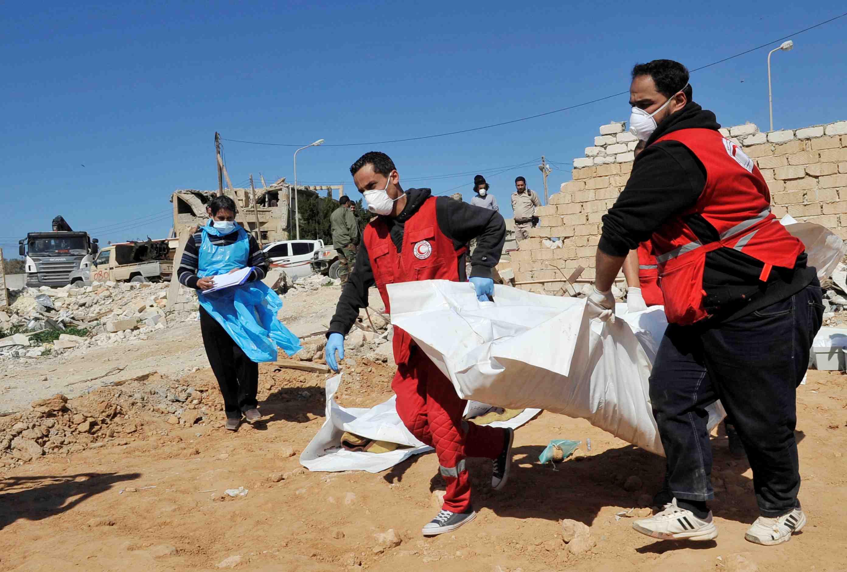 Members of the red crescent evacuate the dead bodies of unidentified people found buried in ganfouda district in benghazi
